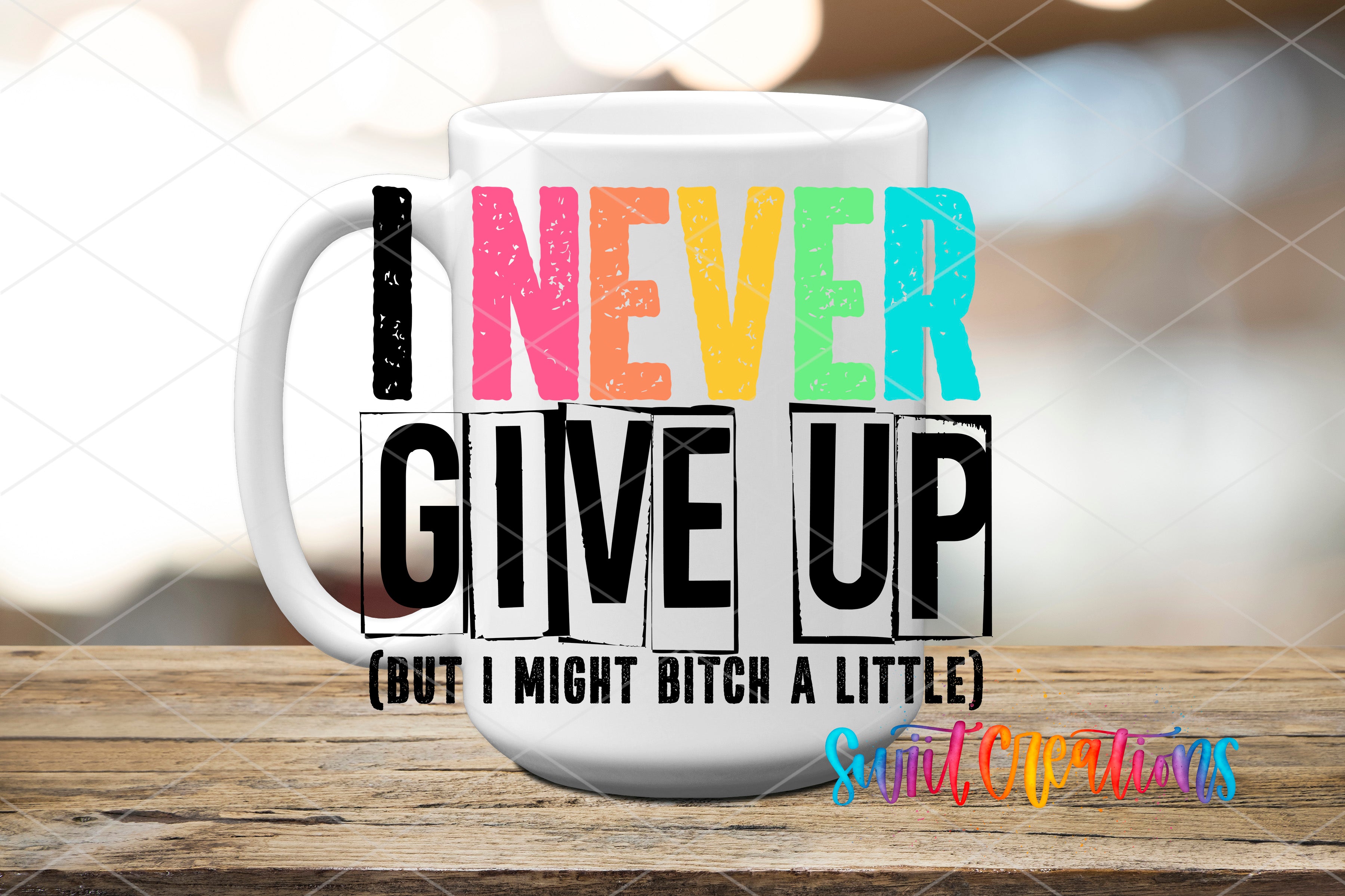 A white mug with colorful text on it, placed on a wooden surface.