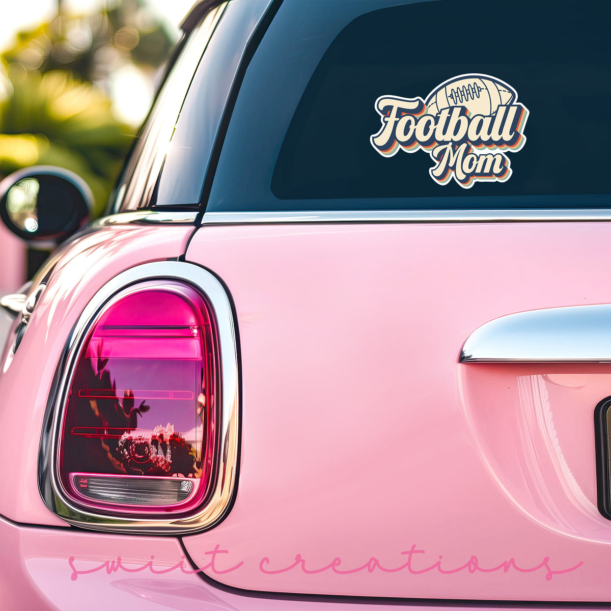 Football Mom sticker on the back window of a pink car