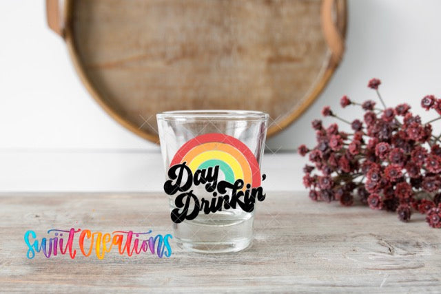 a shot glass sitting on a table with a rainbow sticker on it