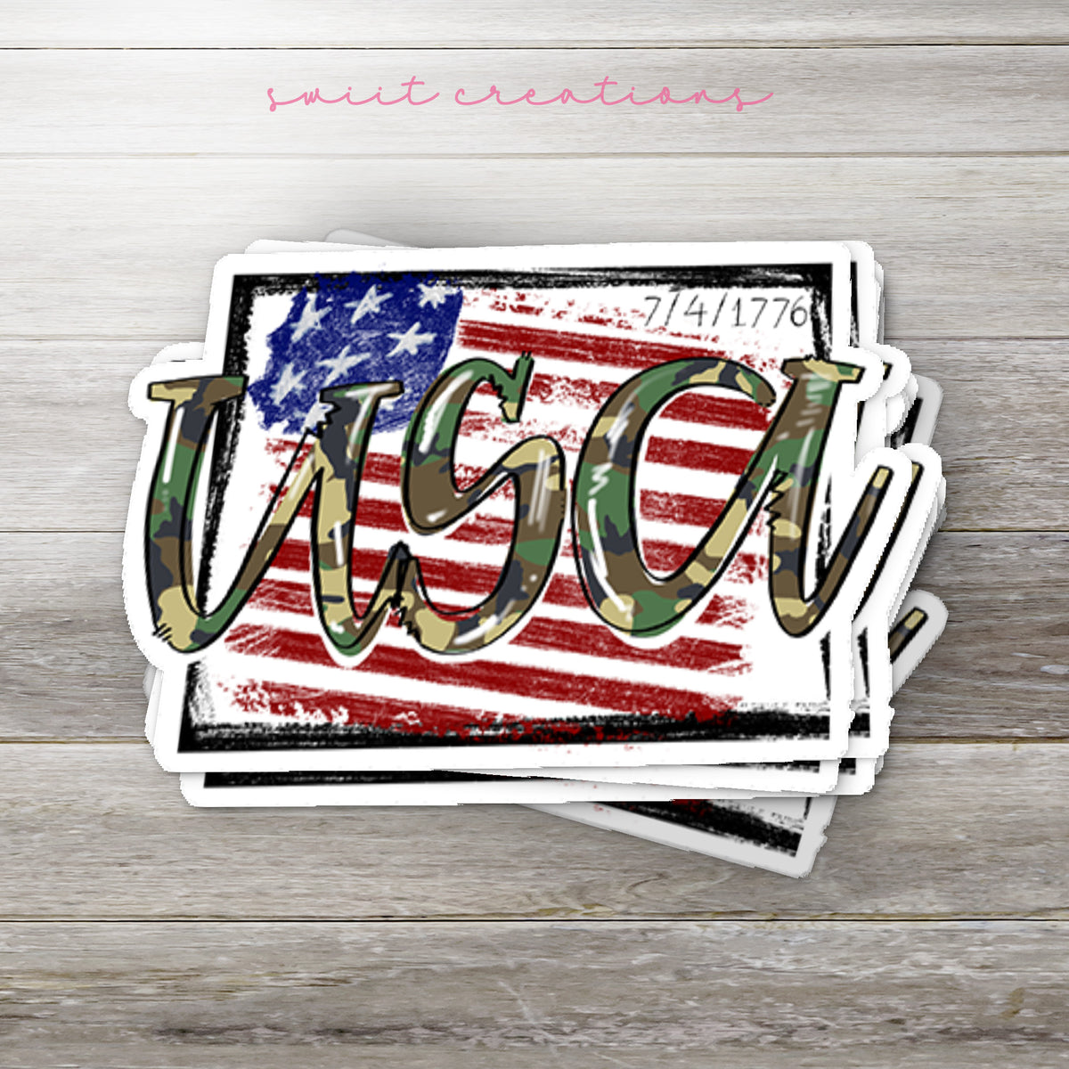 Stack of USA Camo glossy stickers on a gray wood table