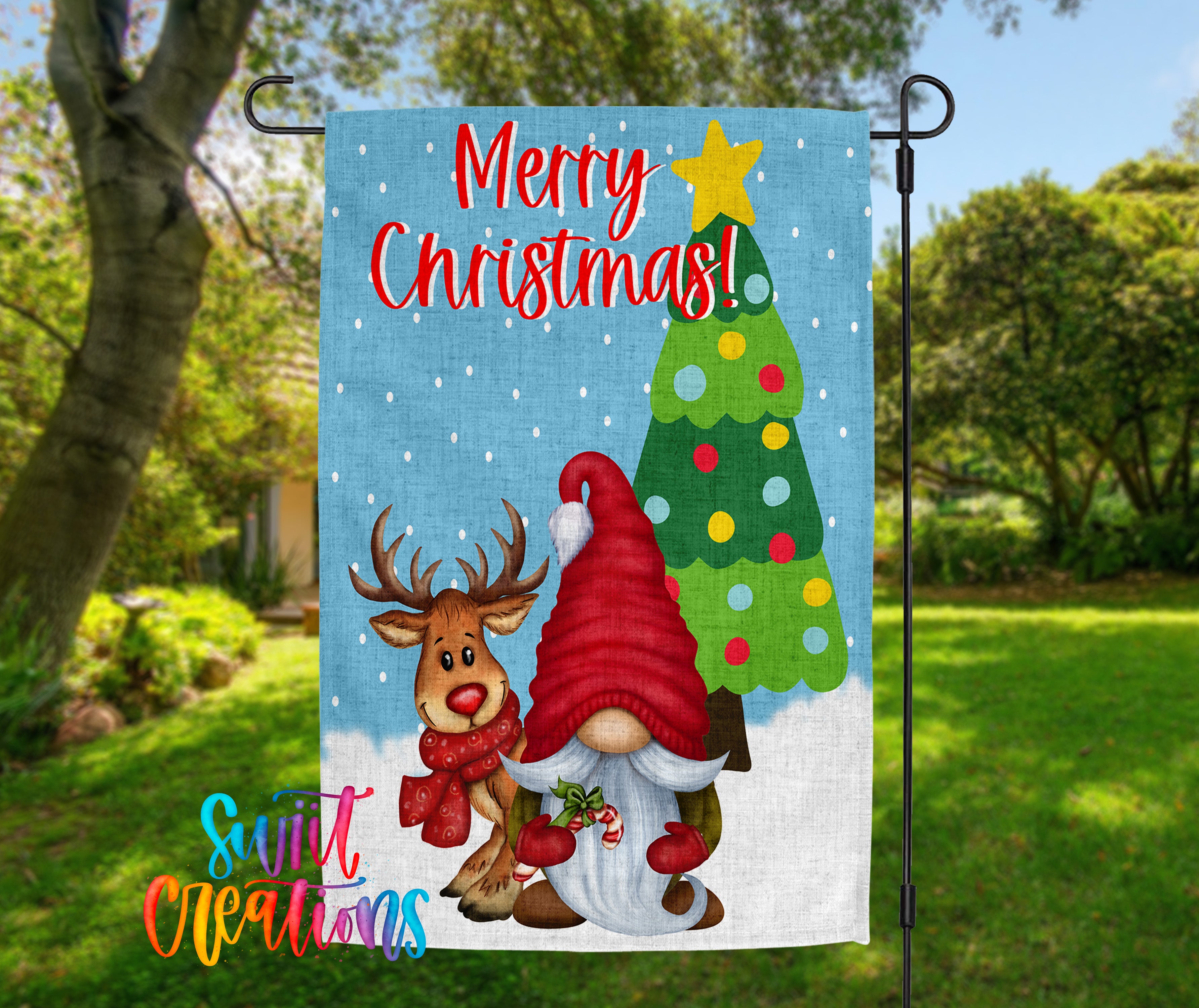 A colorful Christmas-themed garden flag with a gnome and a reindeer, along with a tree and snowflakes, set against a blue background.