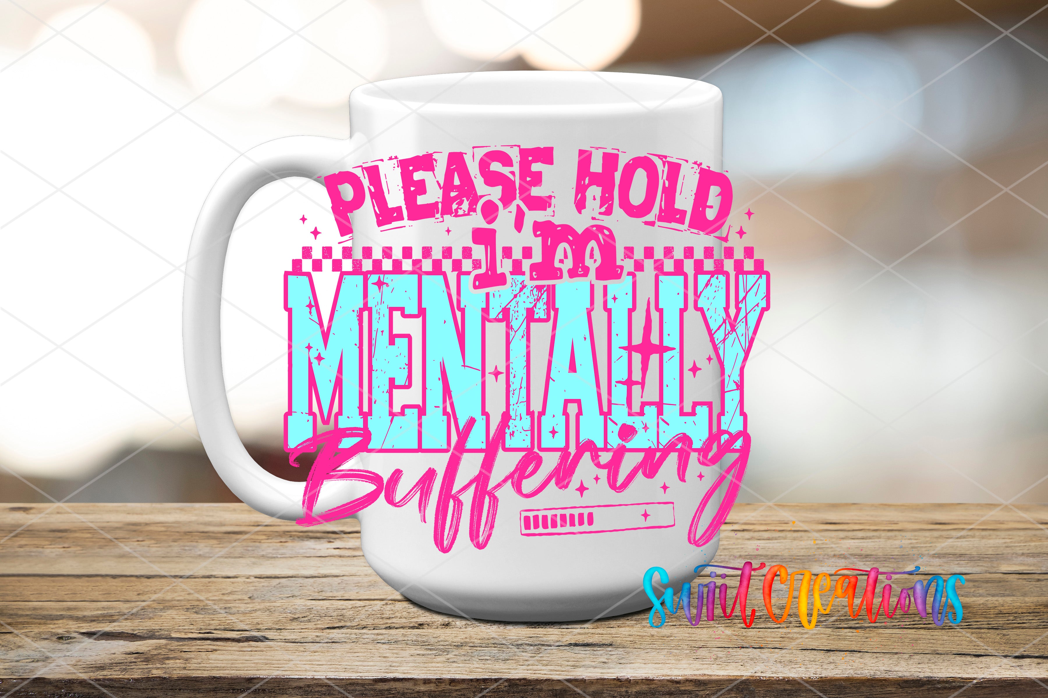A white mug with a colorful text design on it, placed on a wooden surface.