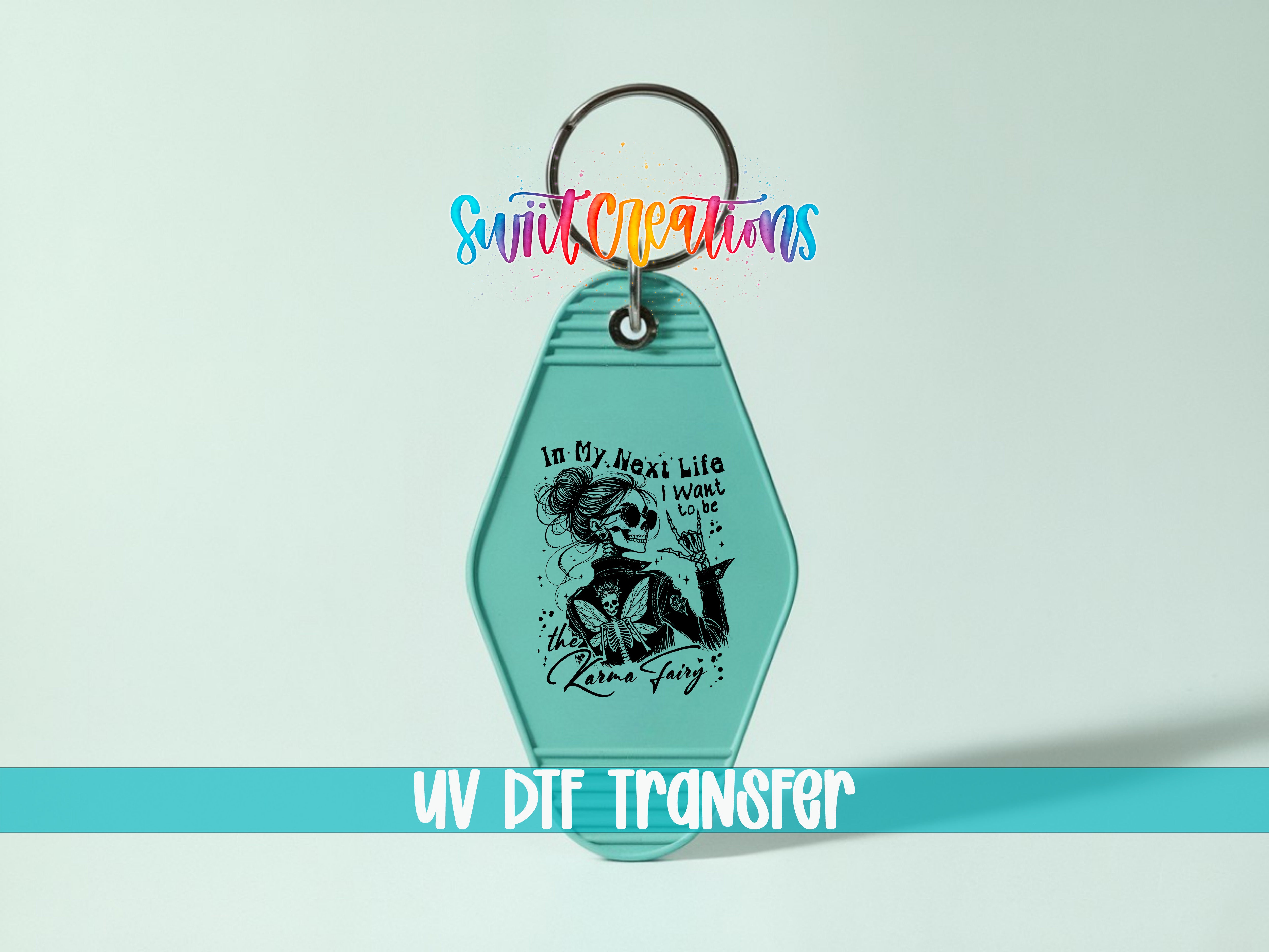 A keychain with a graphic design featuring a woman with a skull and floral elements. The keychain is set against a light blue background, and there is text at the bottom of the image that reads "UV DIF TRANSFER".