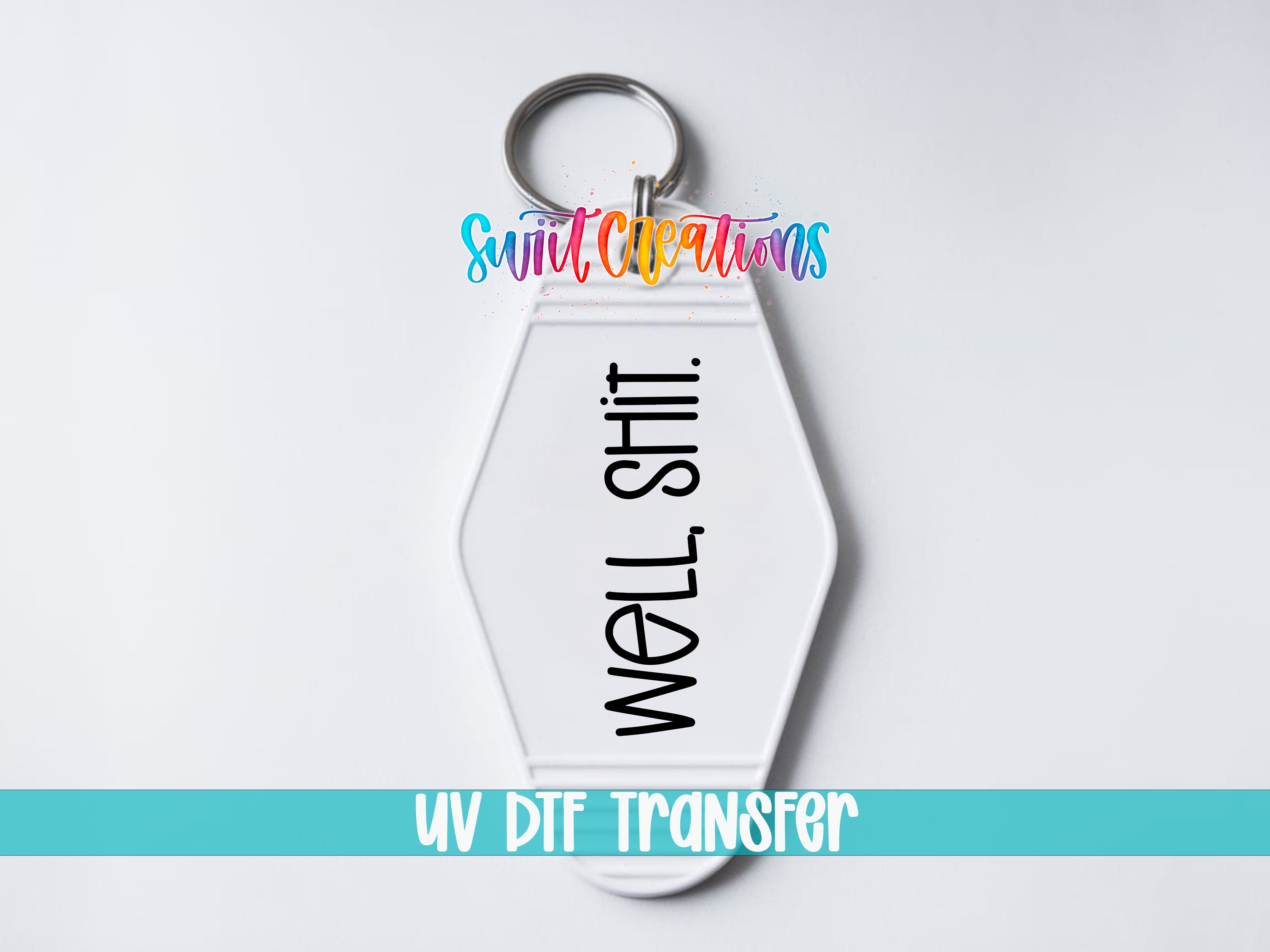A white keychain with the text "WELL SHIT" printed on it, along with a colorful logo and the text "UV DDF Transfers" at the bottom.