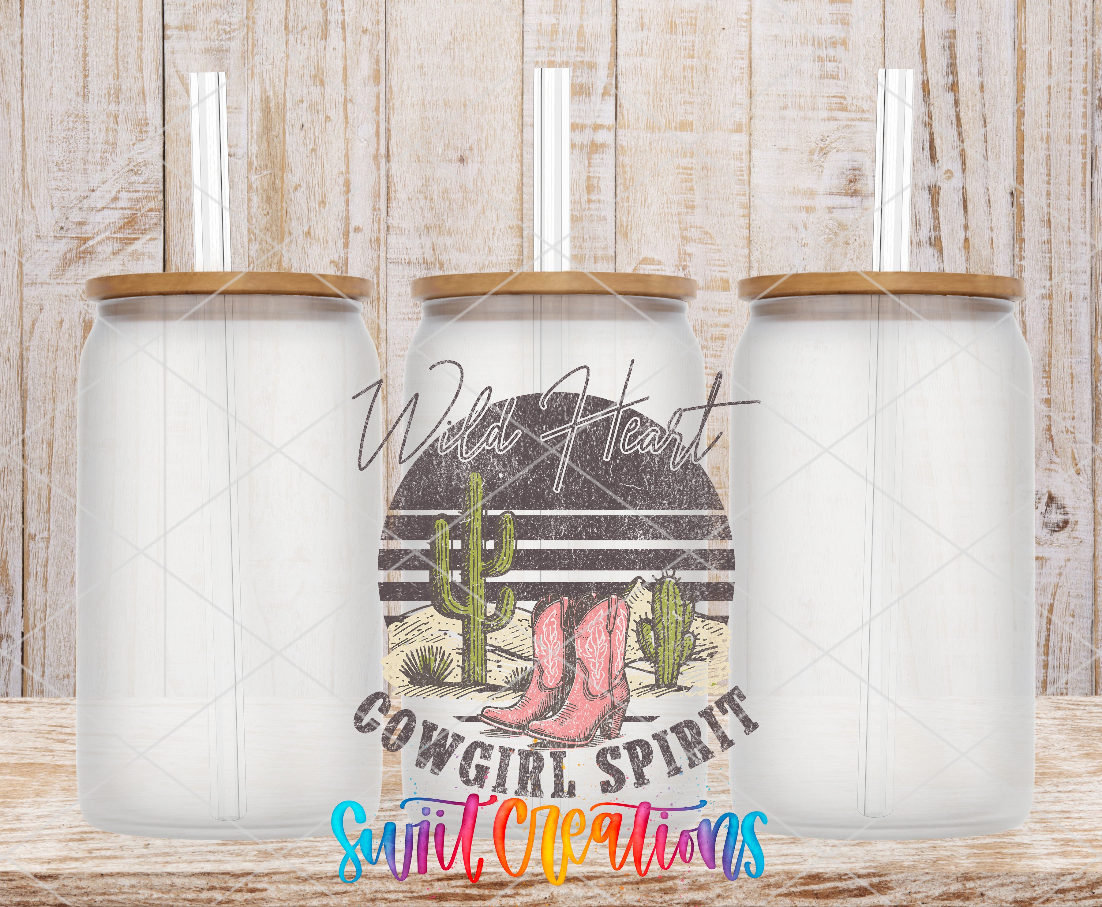 three glass jars with lids, arranged in a row against a wooden background. The jars have a cowboy-themed design, including a cactus and boots. The phrase "Wild Heart Cowgirl Spirit" is written in cursive above the jars, and the phrase "Suite Creations" is written in a colorful, stylized font at the bottom of the image.