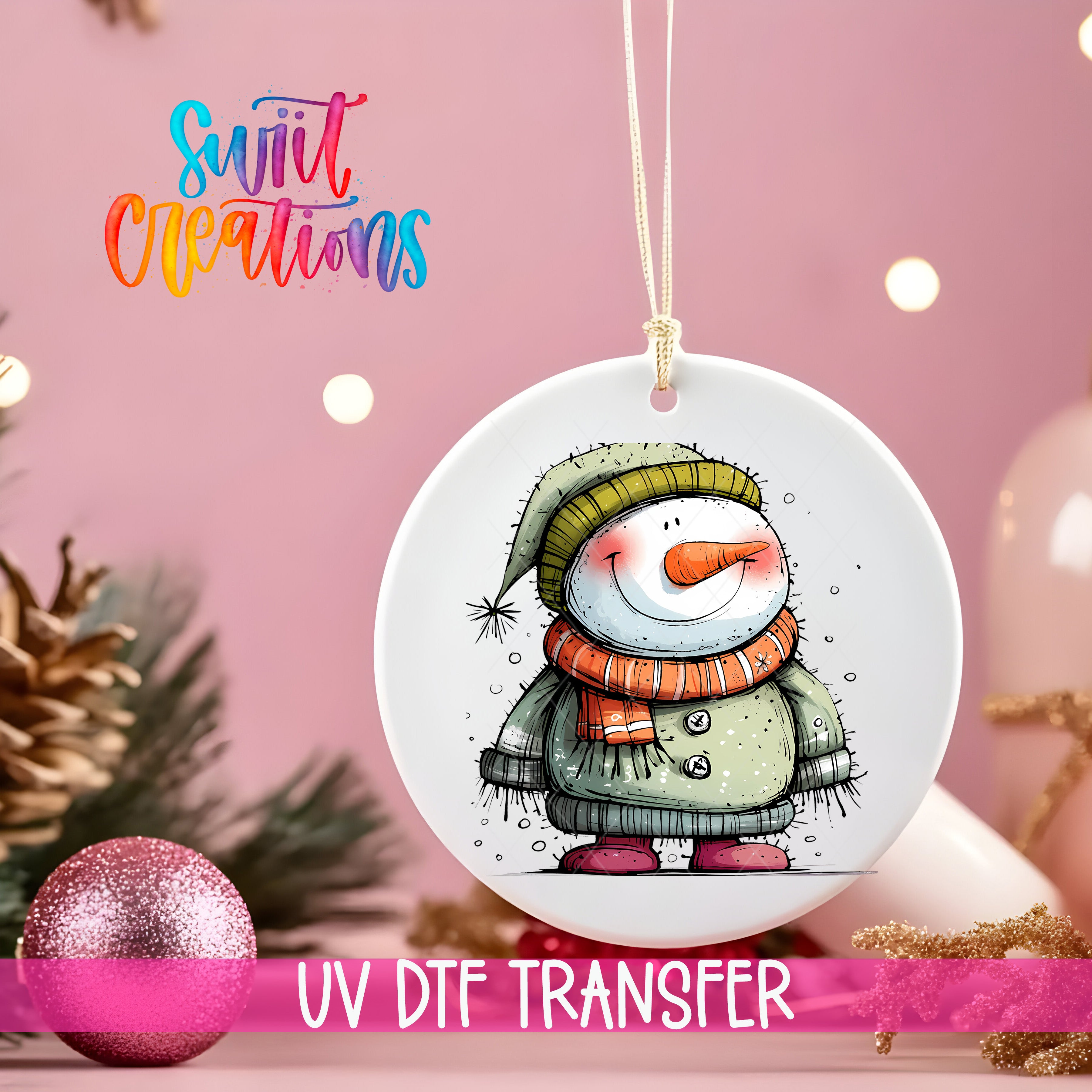 A white ornament with a snowman design hangs against a pink background, with a pink glitter ball and pine cones in the foreground.