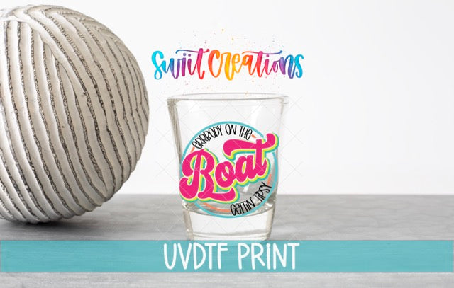 a shot glass next to a ball of yarn
