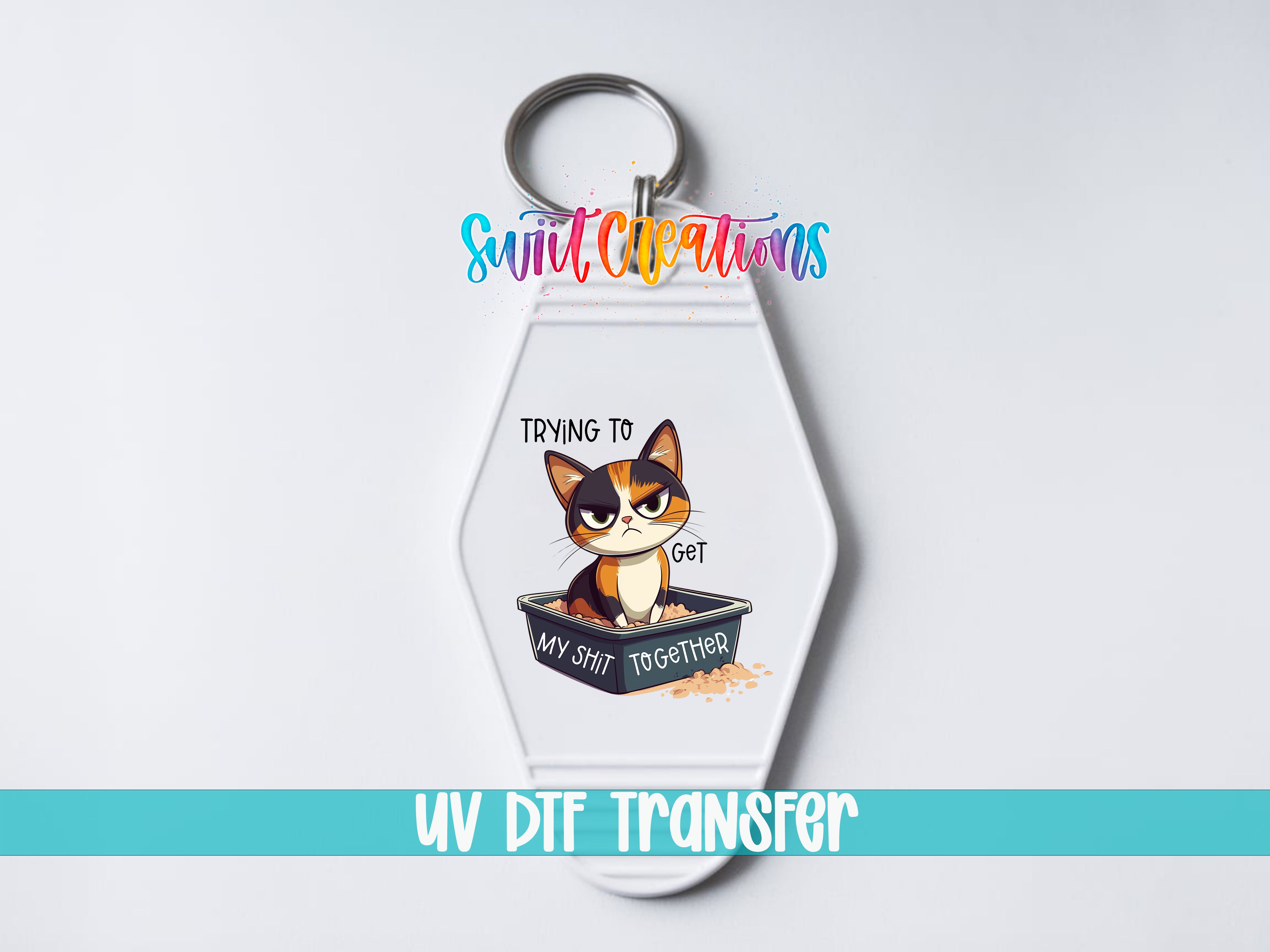 A keychain with a cartoon cat and the text "Trying to get my shit together" printed on it.