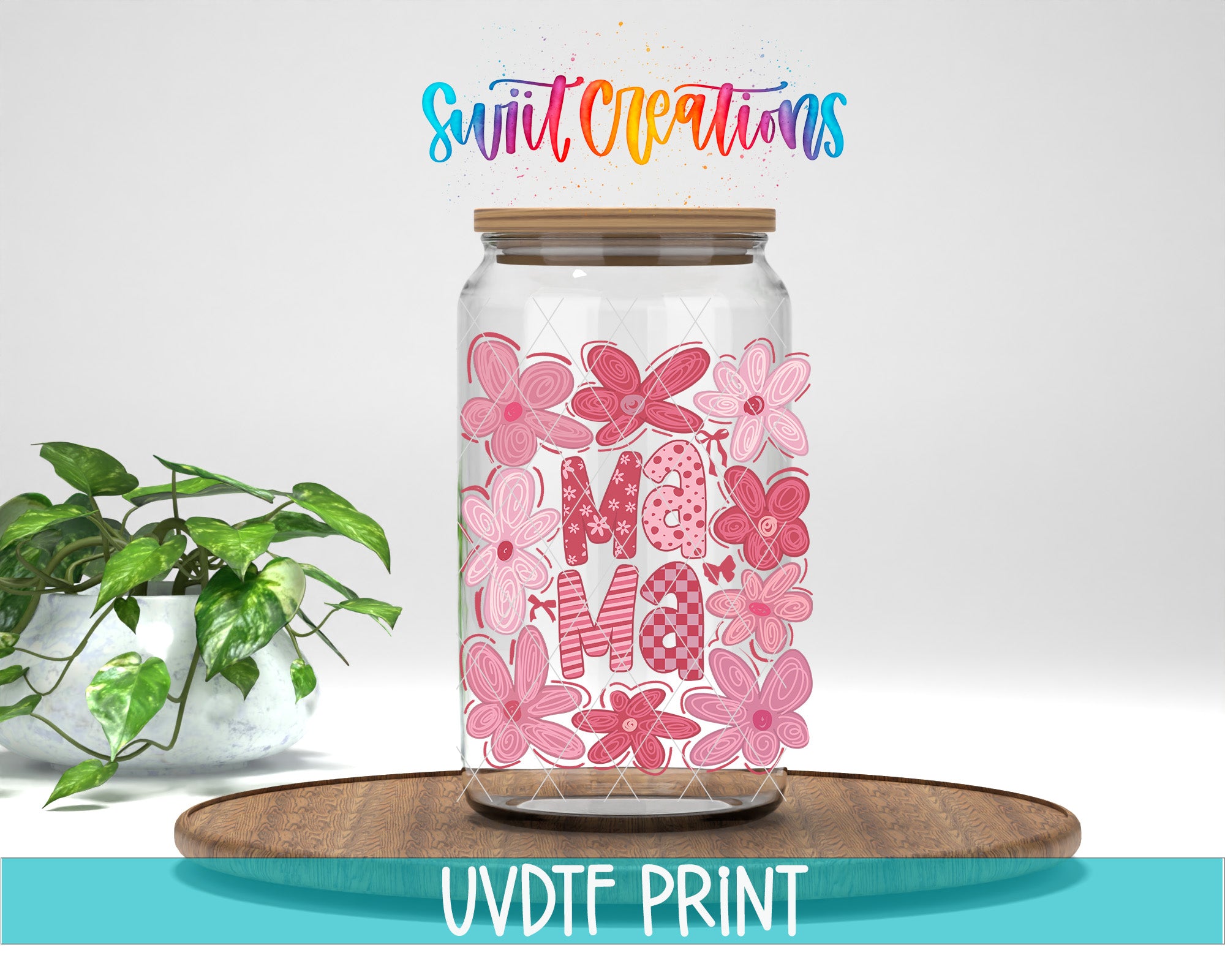 A glass jar filled with pink flowers, with the word "Mama" written on it, placed on a wooden surface. There is also a plant in the background.