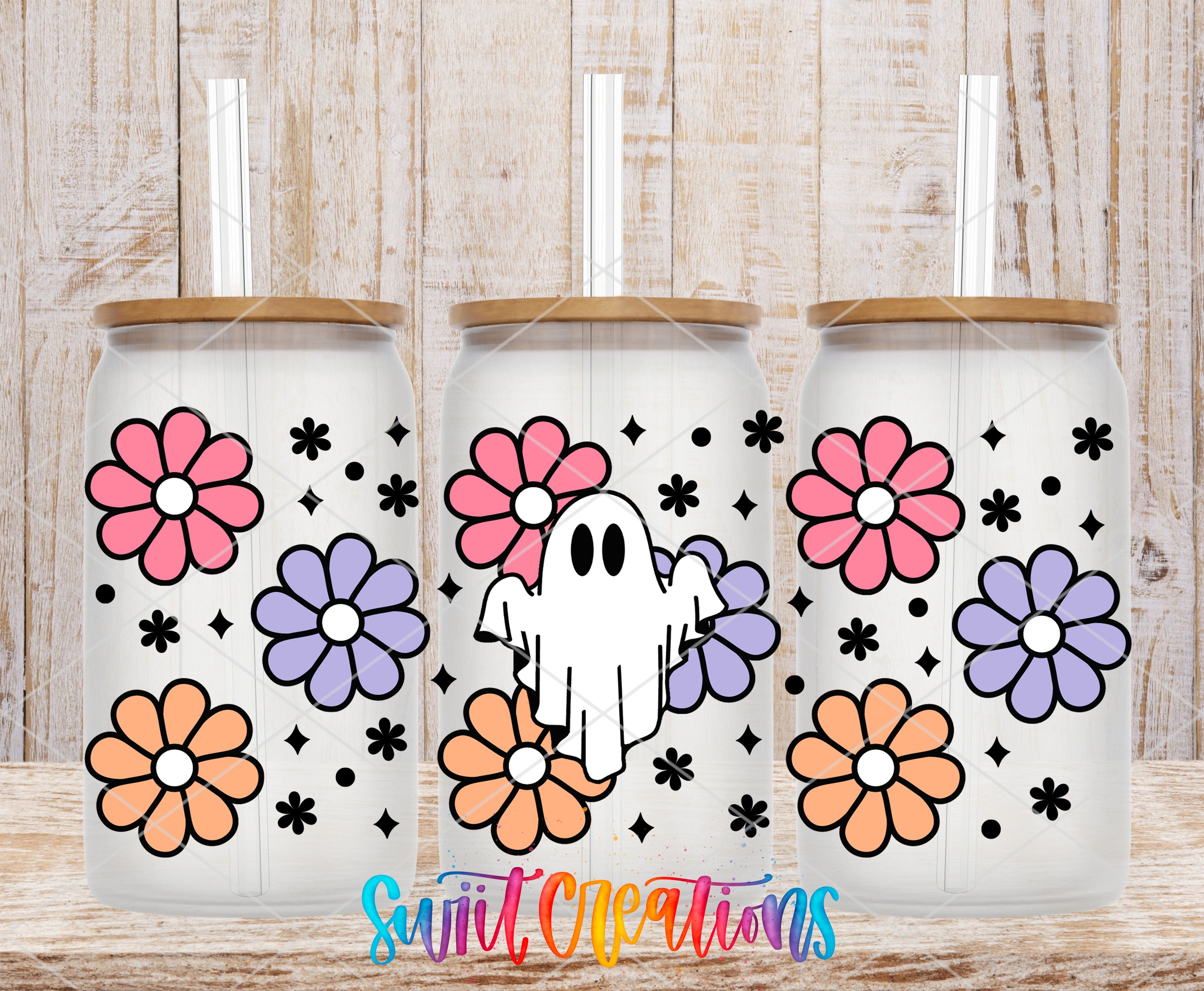 three glass tumblers with a ghost design and colorful flower patterns on them.
