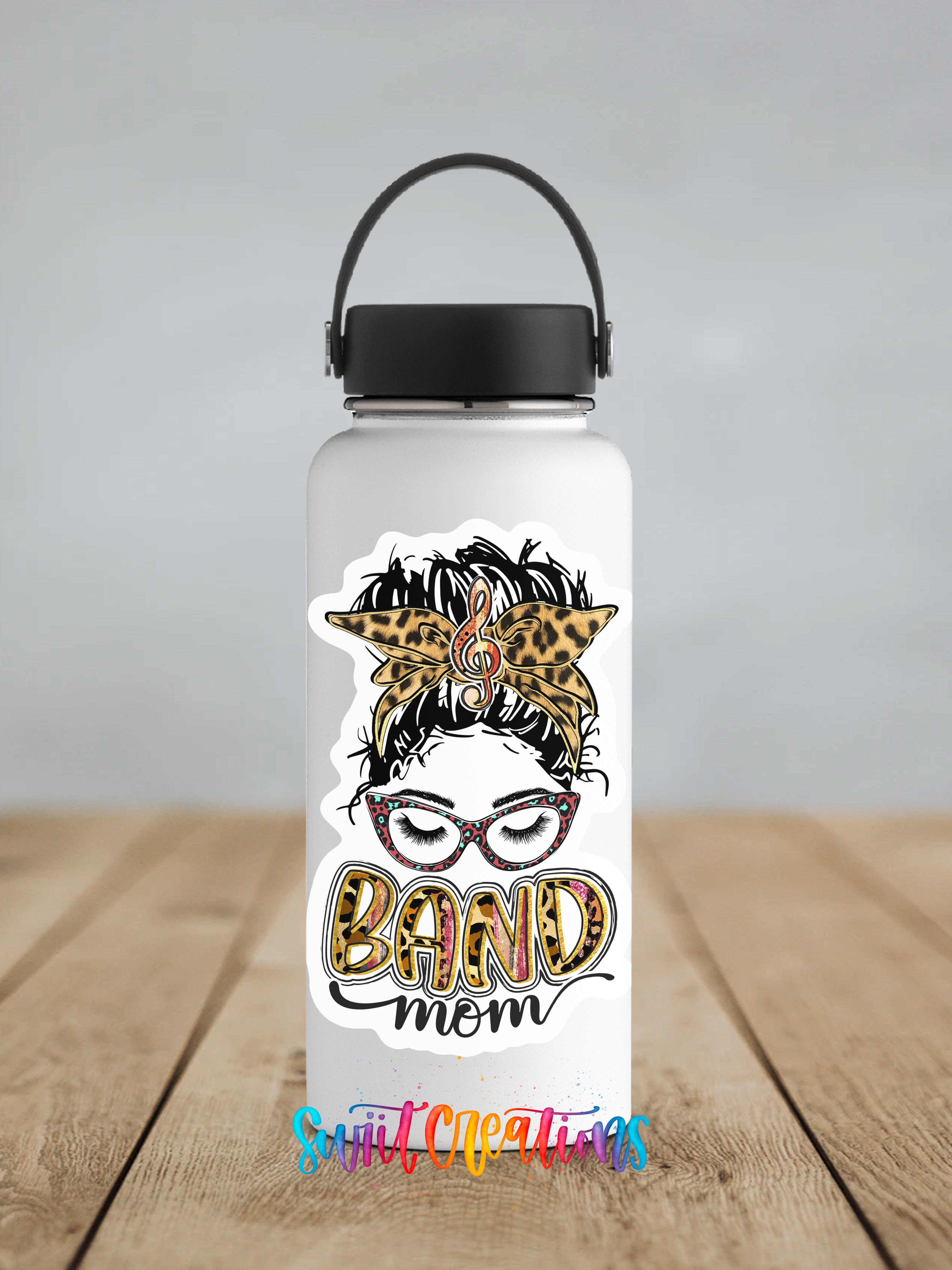 A white water bottle with a black handle and a sticker featuring a stylized image of a woman's face with a leopard print design and the text "BAND mom".