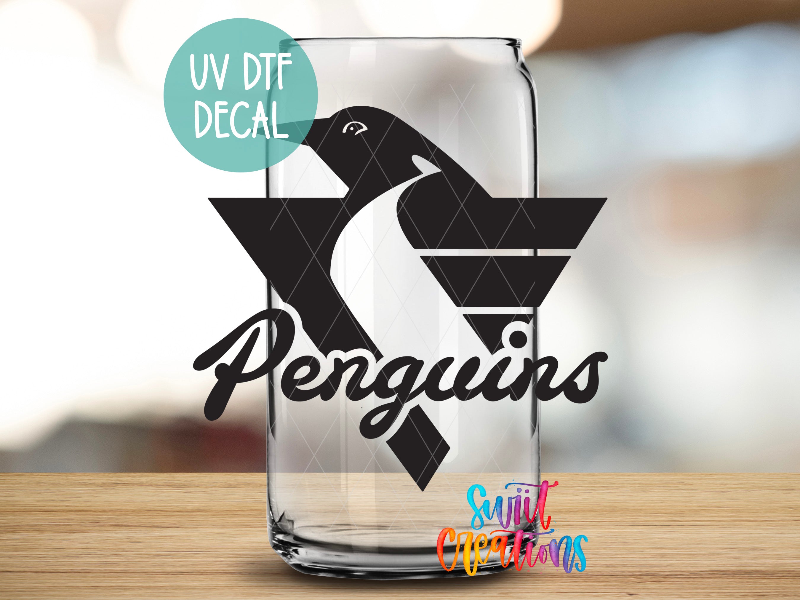 a glass with a penguin on it sitting on a table