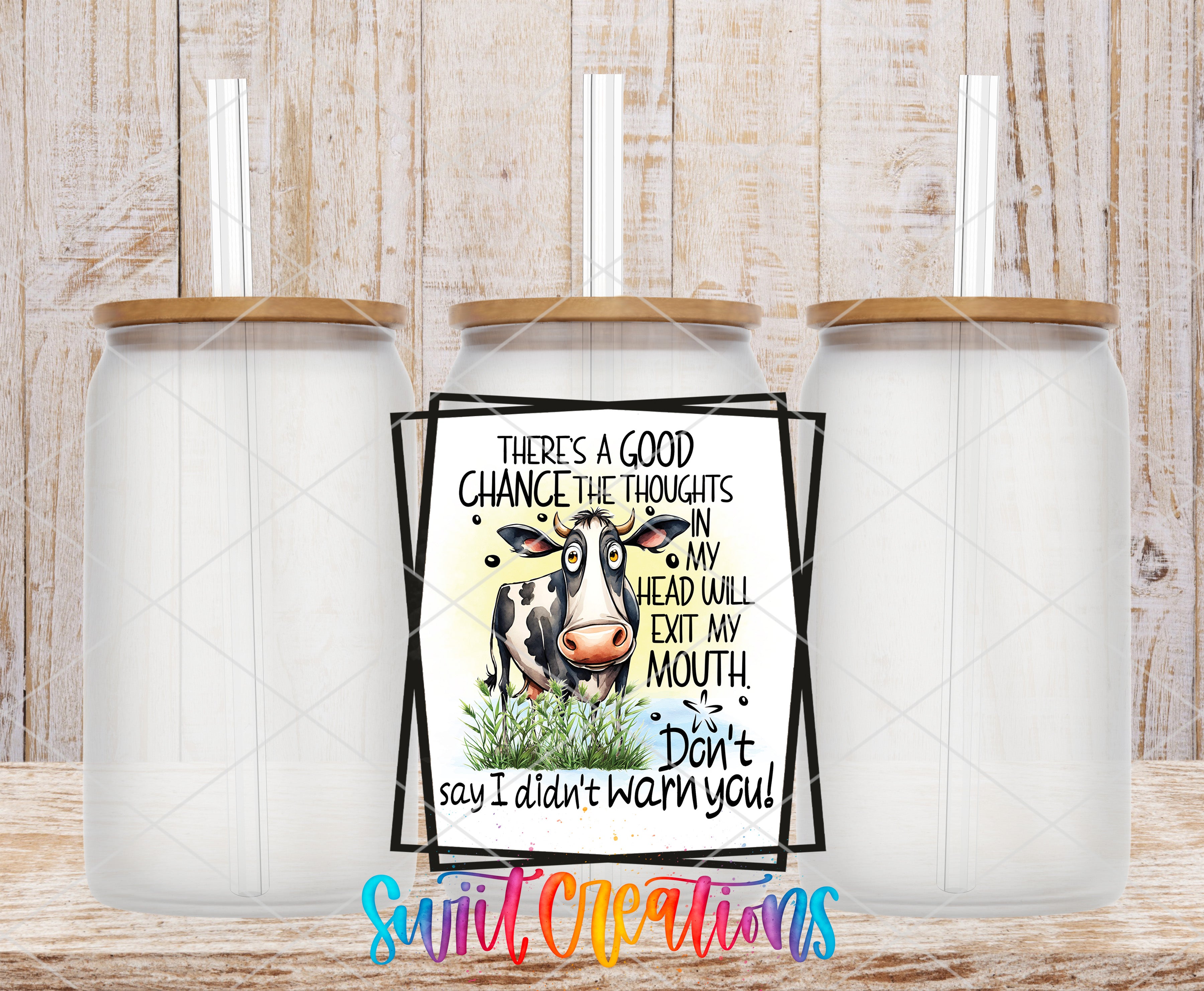 a humorous sign with a cow and the text "There's a good chance the thoughts in my head will escape my mouth. Don't say I didn't warn you!" The sign is placed between two transparent glass jars with wooden lids, creating a visually appealing and playful arrangement.