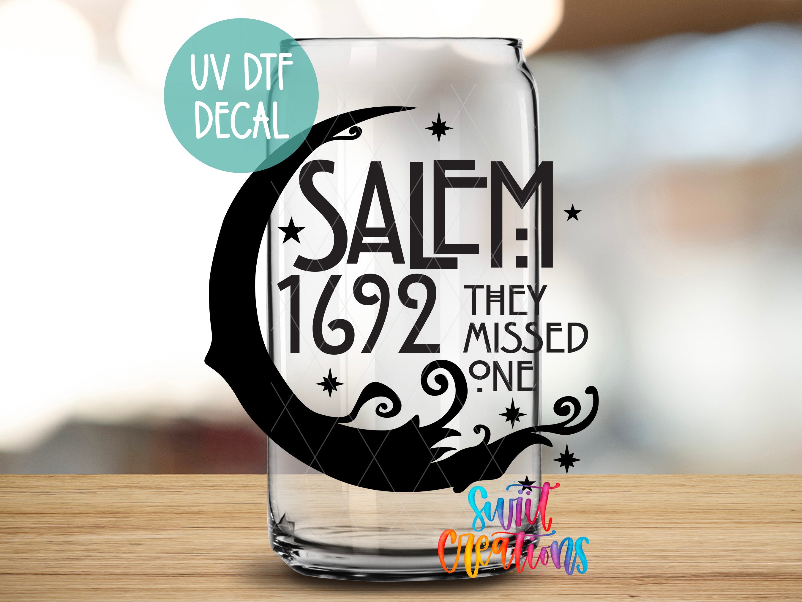 A glass with a UV decal that says "SALEM 1692 THEY MISSED ONE" and a small text that says "Sunlit Creations" at the bottom.