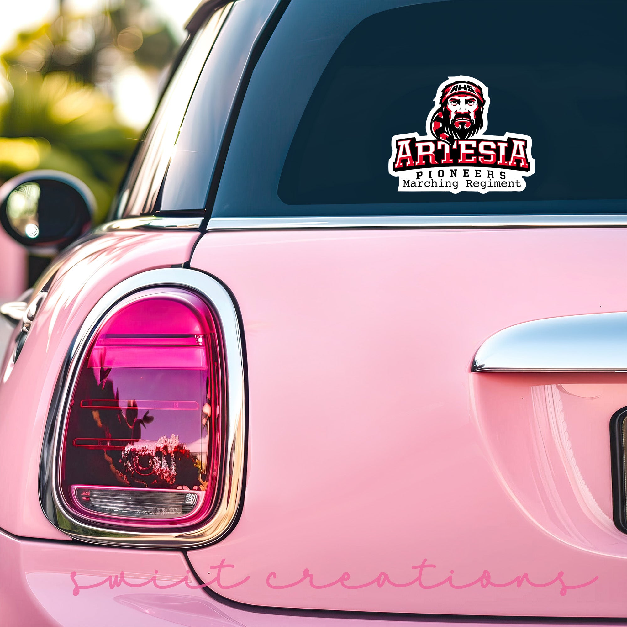 a pink car with a sticker on the back of it