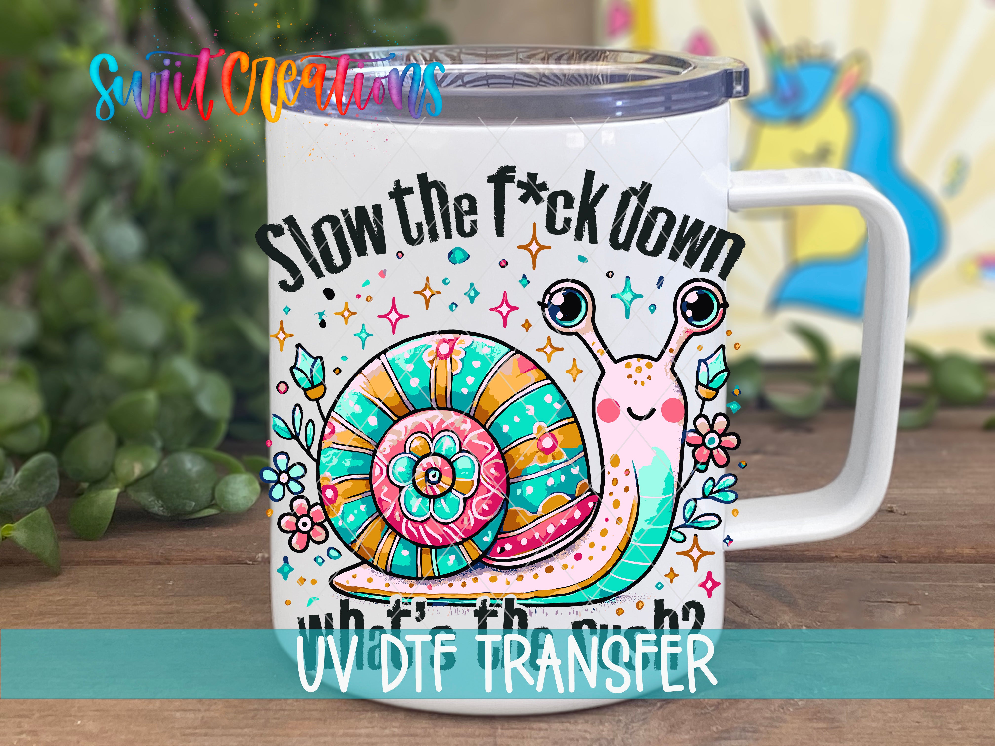 A white mug with a colorful design featuring a snail and the text "Slow the fuck down who's rich?"