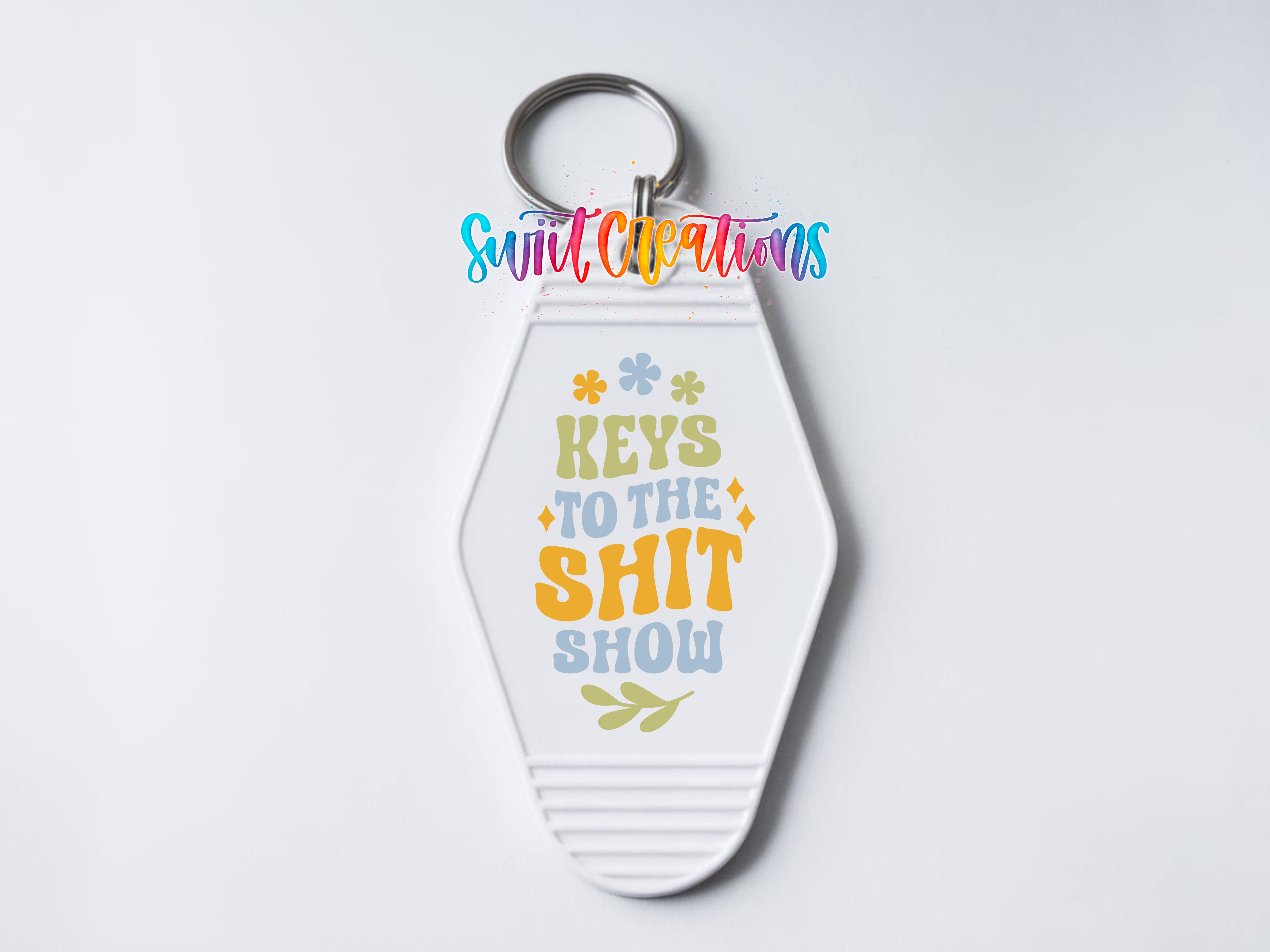 A keychain with a colorful design and text that says "Keys to the shit show".