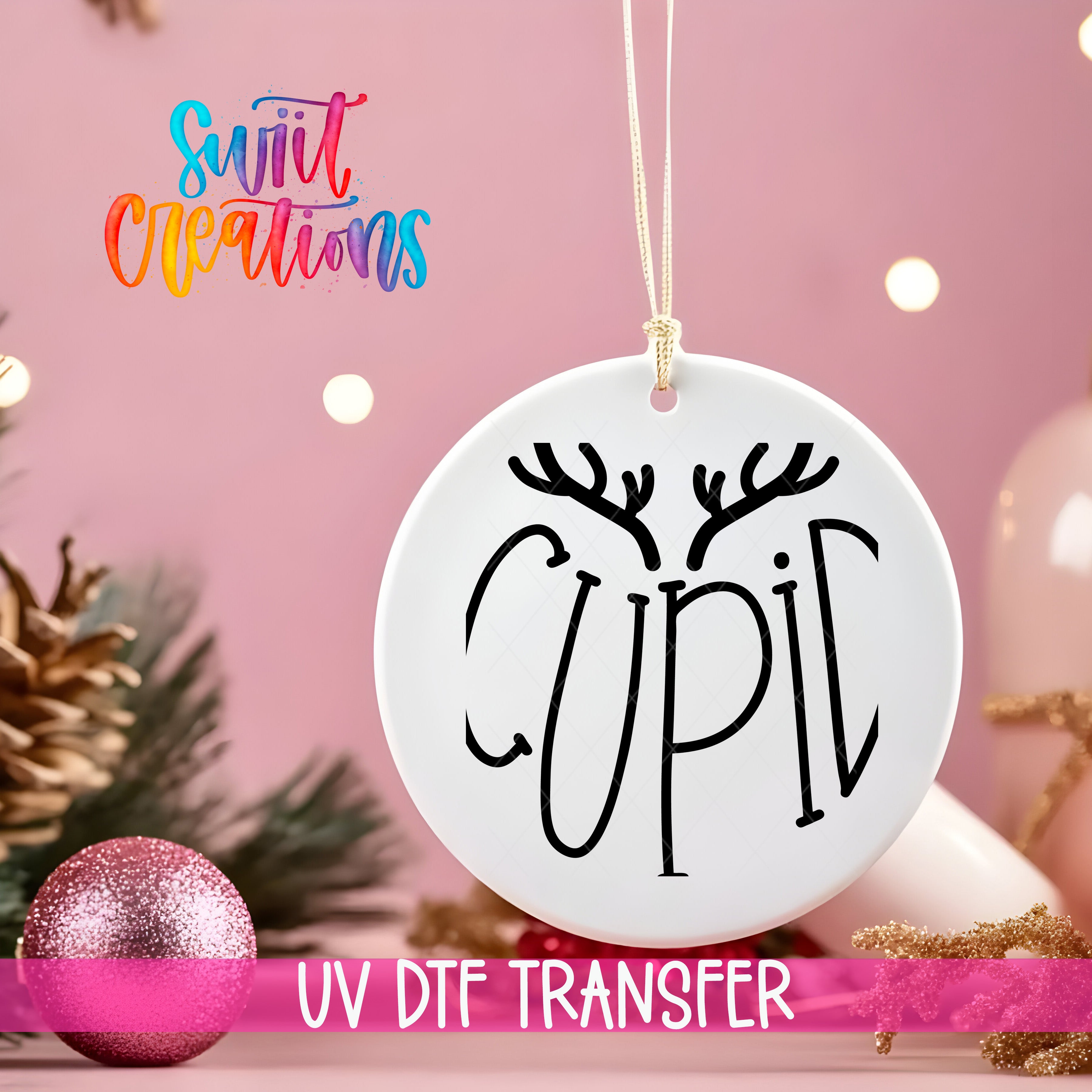 A white ornament with the word "CUPIL" written on it, hanging on a string against a pink background with Christmas decorations and a pink glitter ornament.