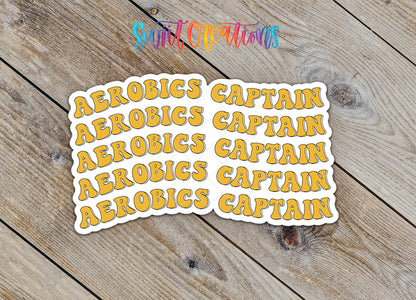 Stickers with the word "CAPTAIN" repeated in a playful, artistic font on a wooden background.