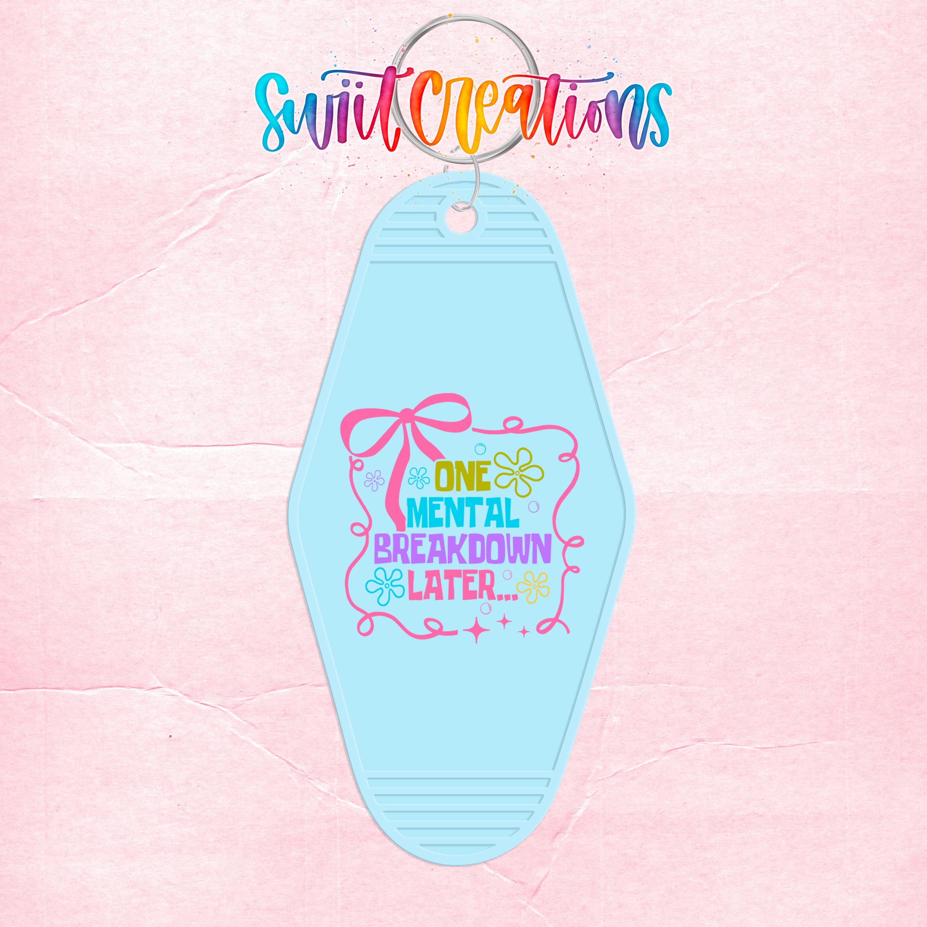 A keychain with a light blue color and a colorful design featuring text and decorative elements.