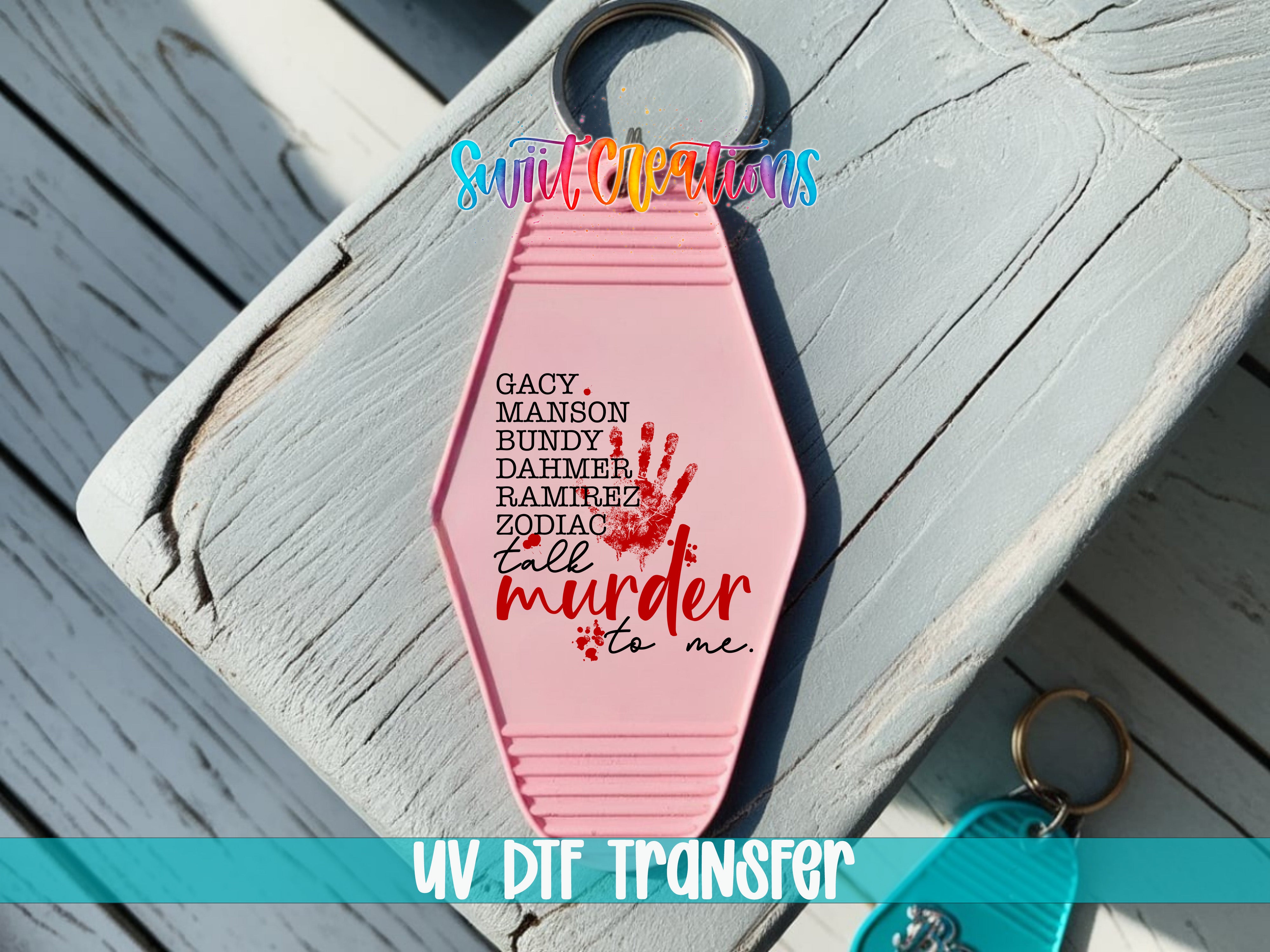 A pink keychain with a handprint design and text printed on it, placed on a wooden surface.