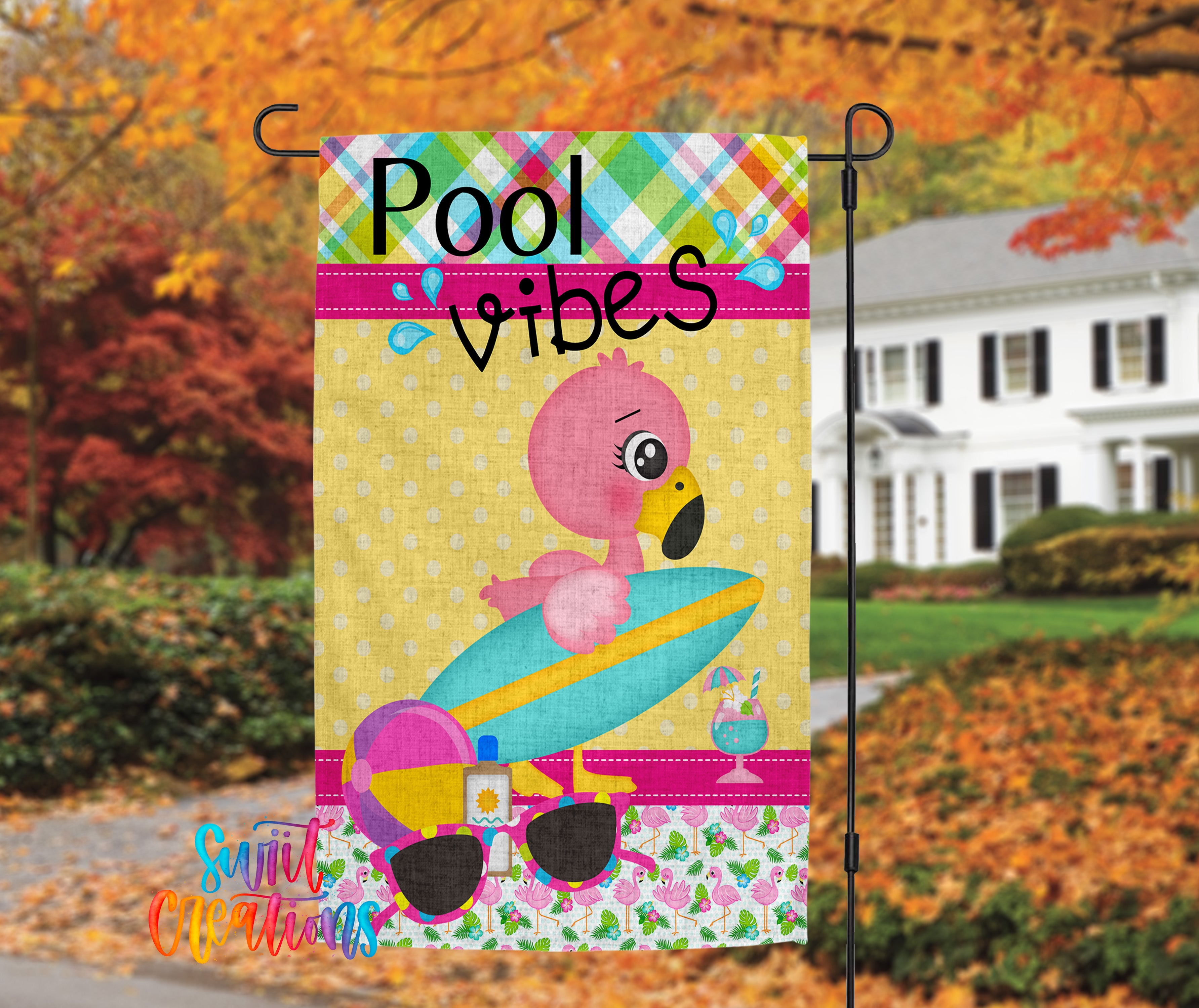 A colorful flag with a pink flamingo and a surfboard, along with the text "Pool vibes" and a house in the background.