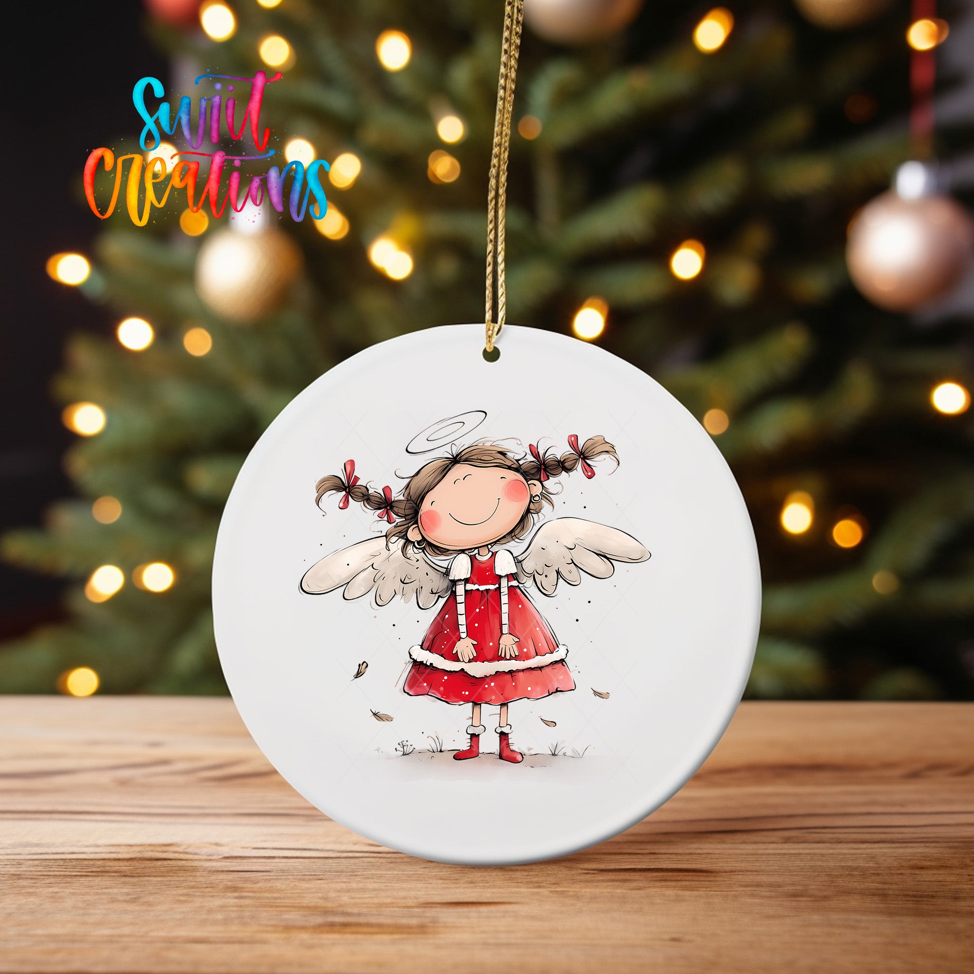 A white oval ornament featuring a smiling girl with angel wings, set against a blurred background of a Christmas tree with twinkling lights.