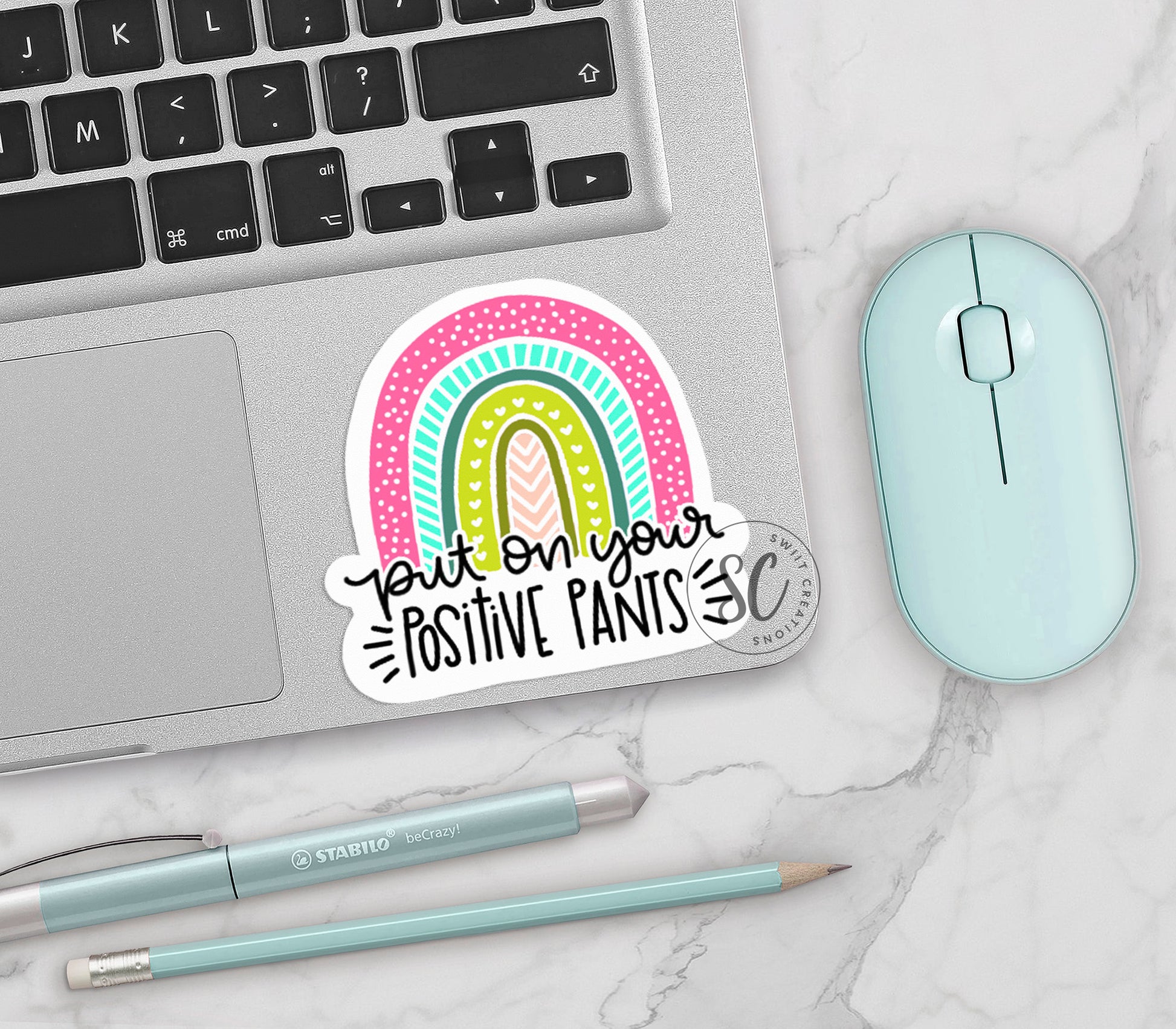 a laptop with a sticker on it next to a mouse