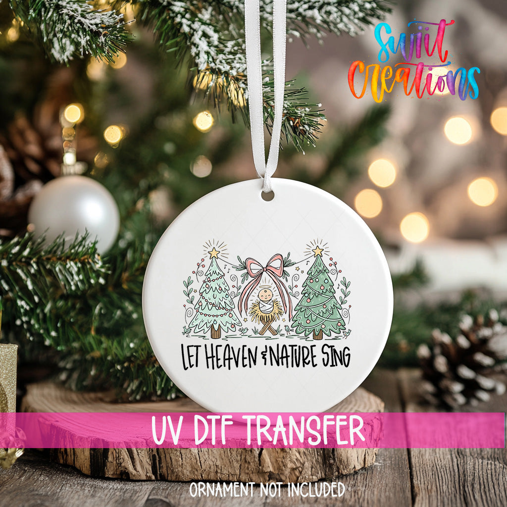 A white ornament with a Christmas tree design hangs on a tree branch, with a pink ribbon around it.