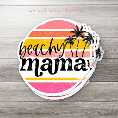 Stack of Beachy Mama glossy stickers on a gray wood table