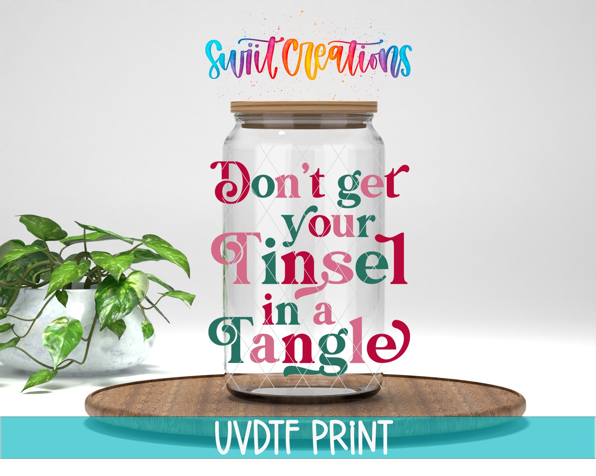 a clear glass jar with a wooden lid, placed on a wooden surface. The jar is surrounded by a potted plant, and there is text above the jar that reads "Don't get your tinsel in a tangle".