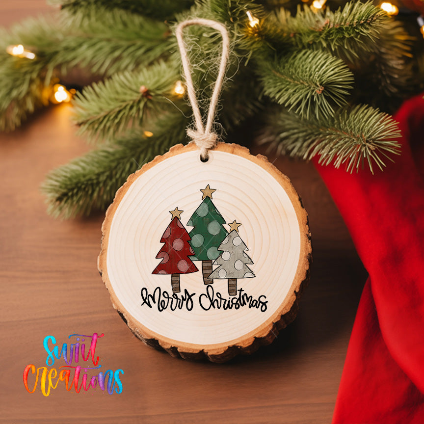 A wooden ornament with a Christmas tree design hangs on a tree branch, surrounded by twinkling lights.