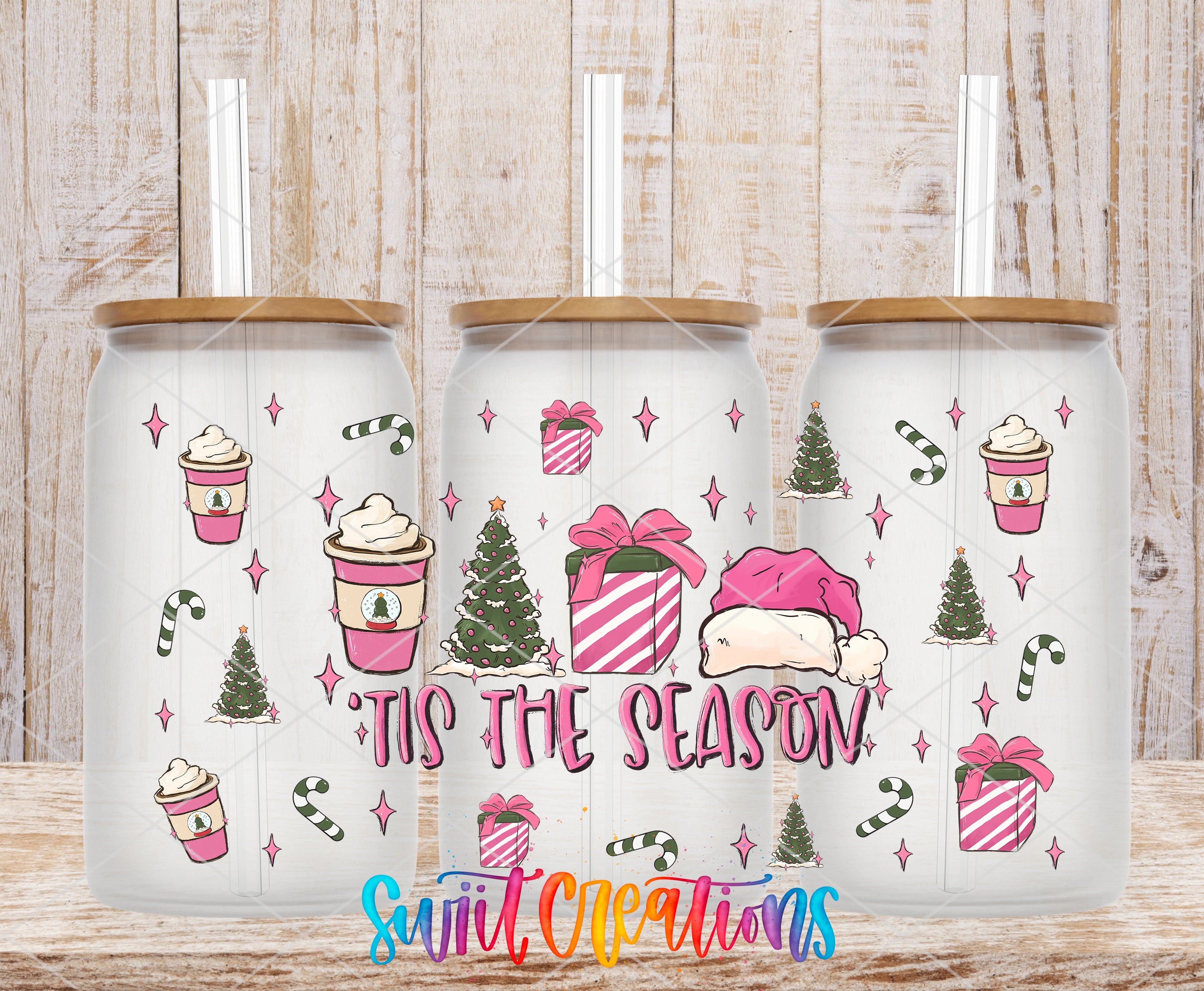 A set of three white tumblers with a festive holiday theme, featuring illustrations of Christmas trees, presents, and a Santa hat. The text "Tis the Season!" is prominently displayed on the tumblers.