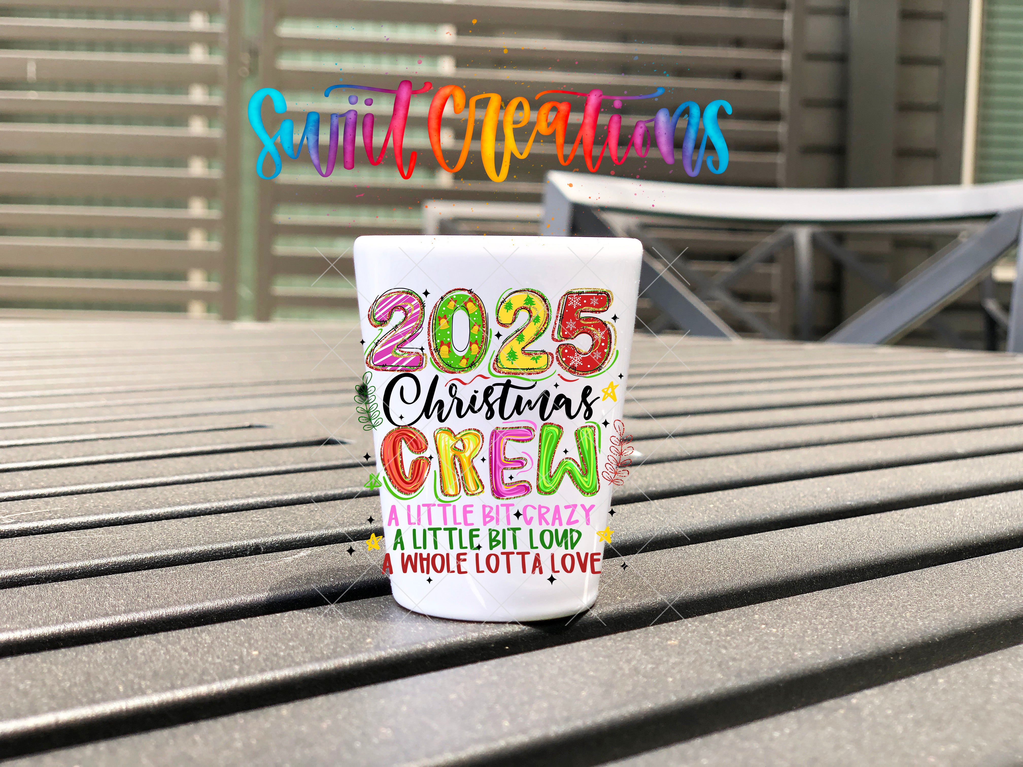 A colorful mug with the text "SWIFT CREATIONS" and "25 Christmas Crew" printed on it, sitting on a wooden surface.