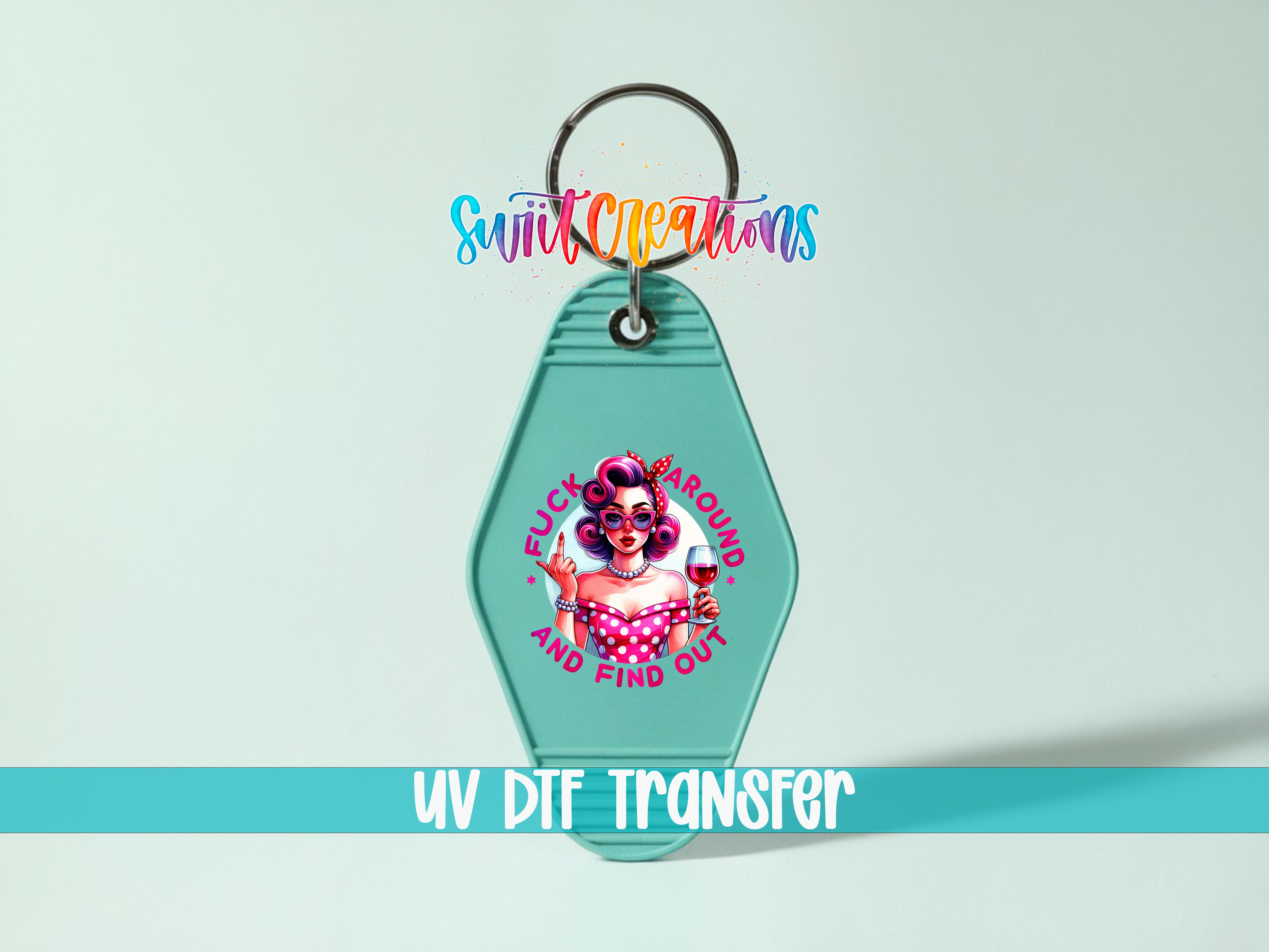 A keychain with a colorful design featuring a woman and the text "FUCK AROUND AND FIND OUT" printed on it.