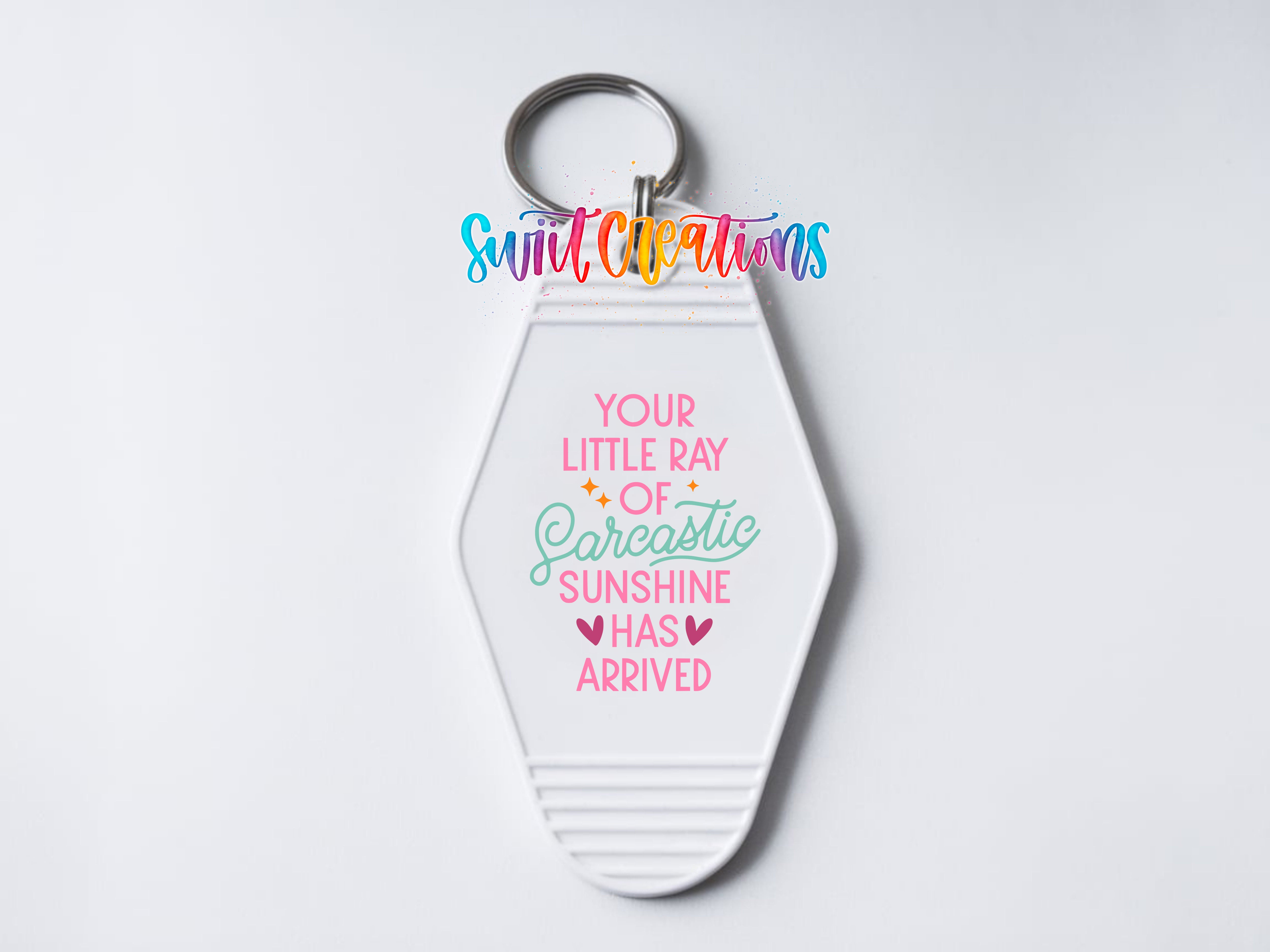A keychain with a message that says "Your little ray of sunshine has arrived" in a colorful, playful font.