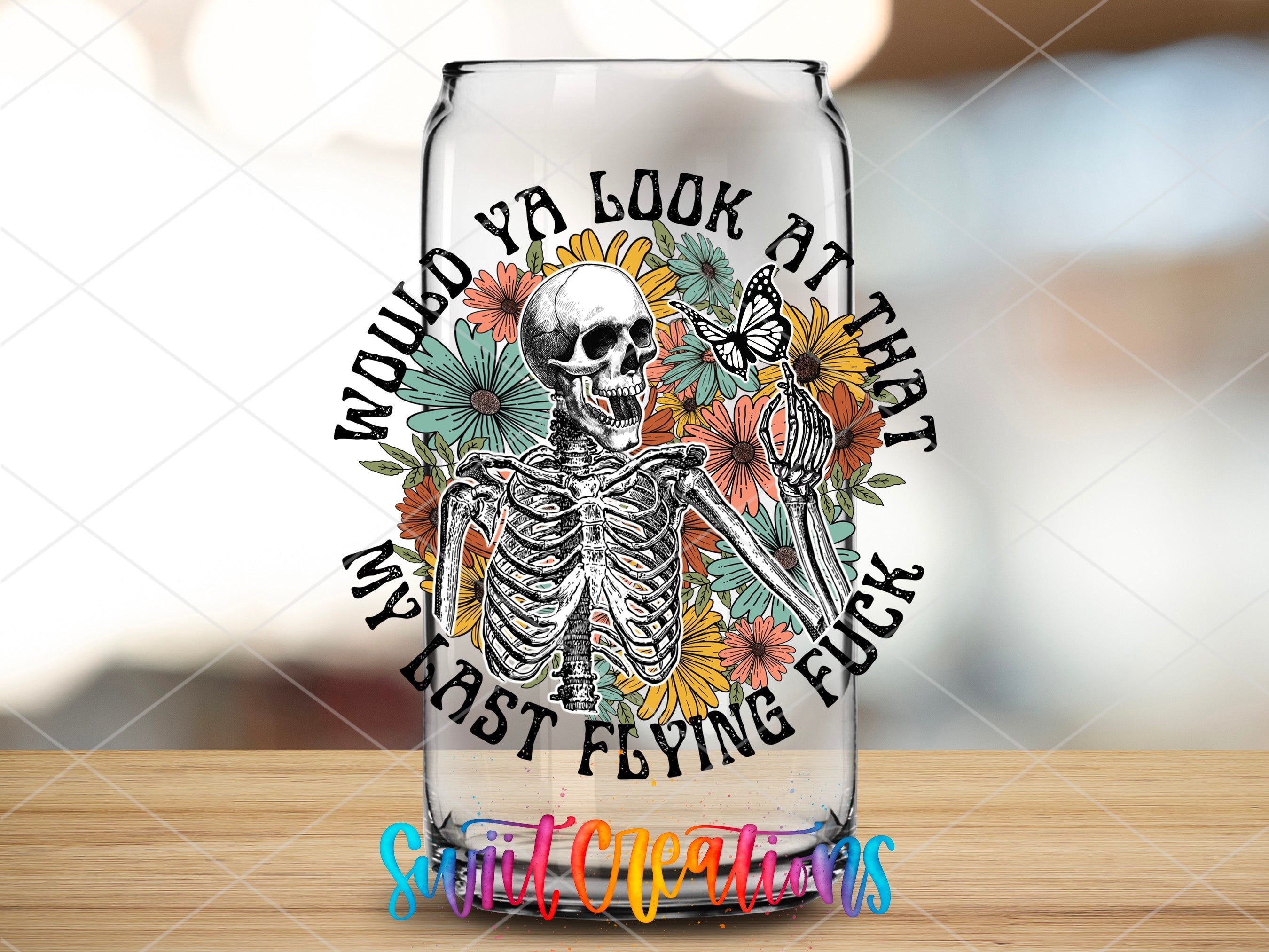 a glass with a skeleton and flowers on it
