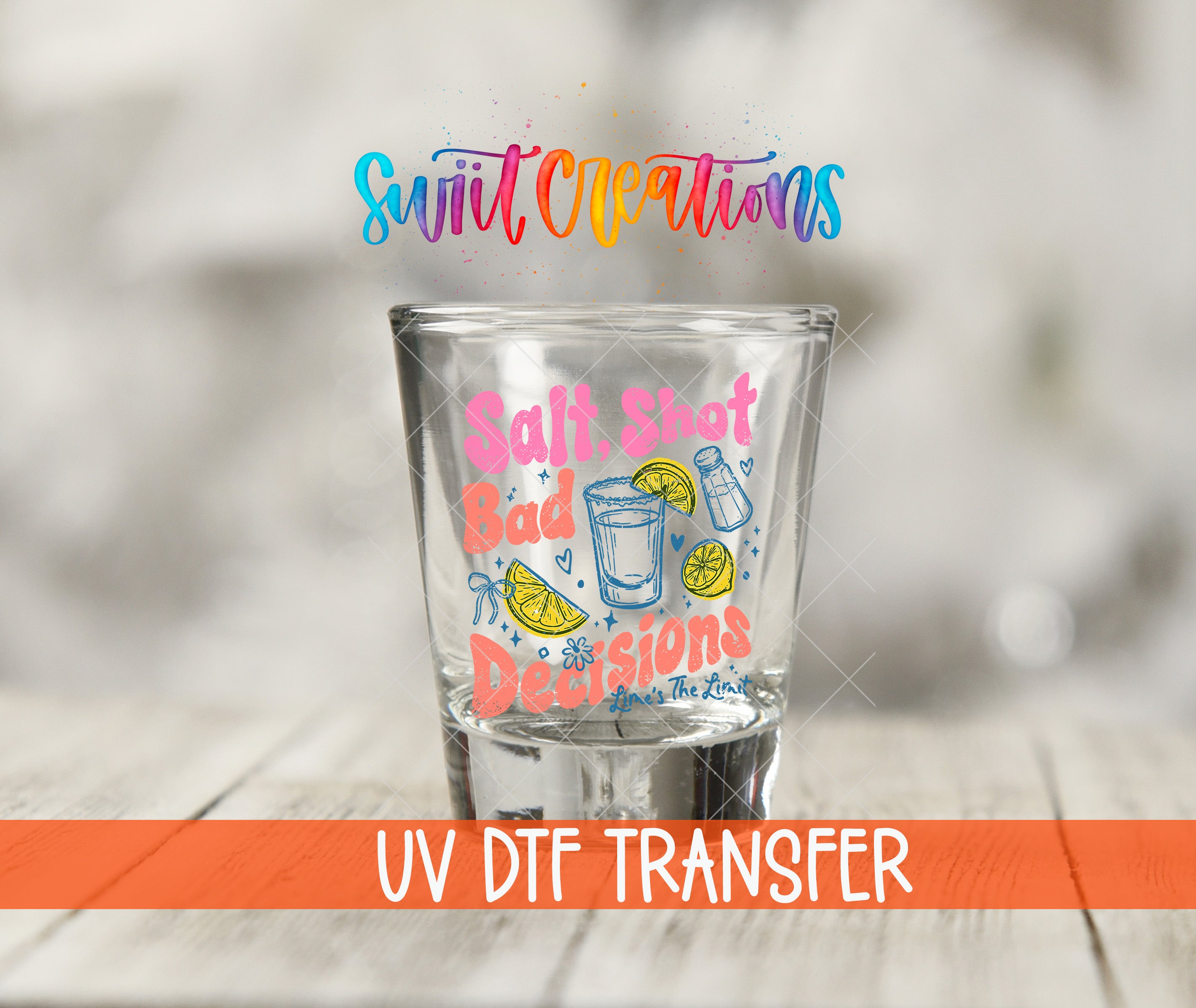 A shot glass with a colorful design and text printed on it, placed on a wooden surface.