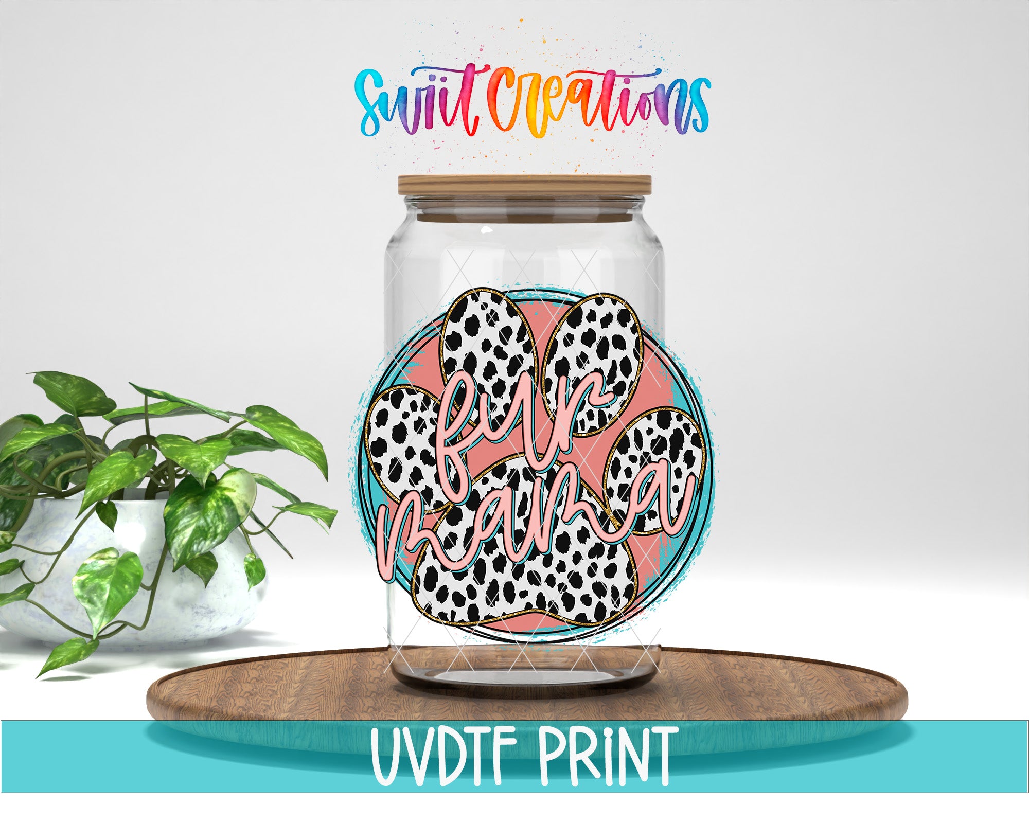 a glass jar with a paw print design and the text "Furry Mom" on it, placed on a wooden surface. There is also a potted plant in the background.