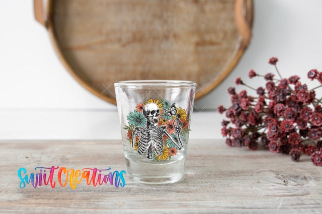 a shot glass with a skeleton design on it