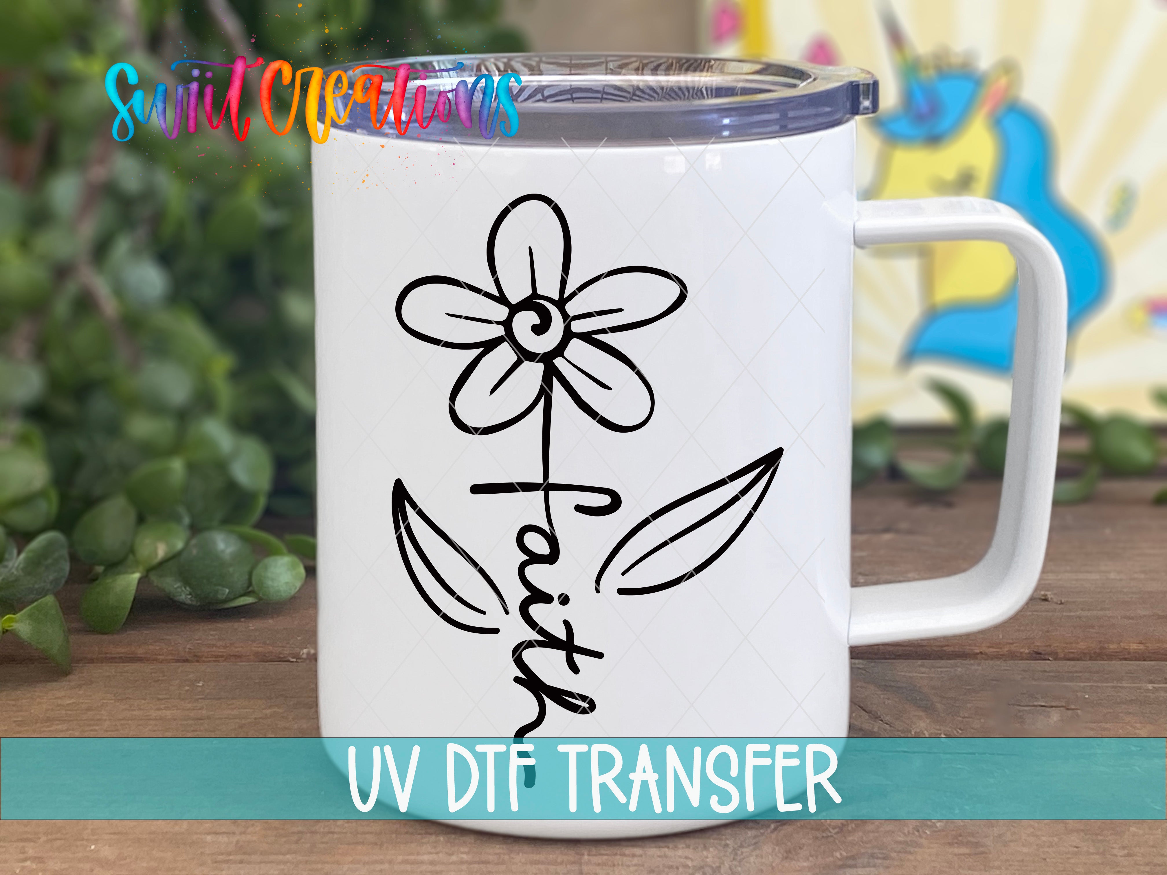 A white ceramic mug with a black flower design and the word "Faith" printed on it, placed on a wooden surface.