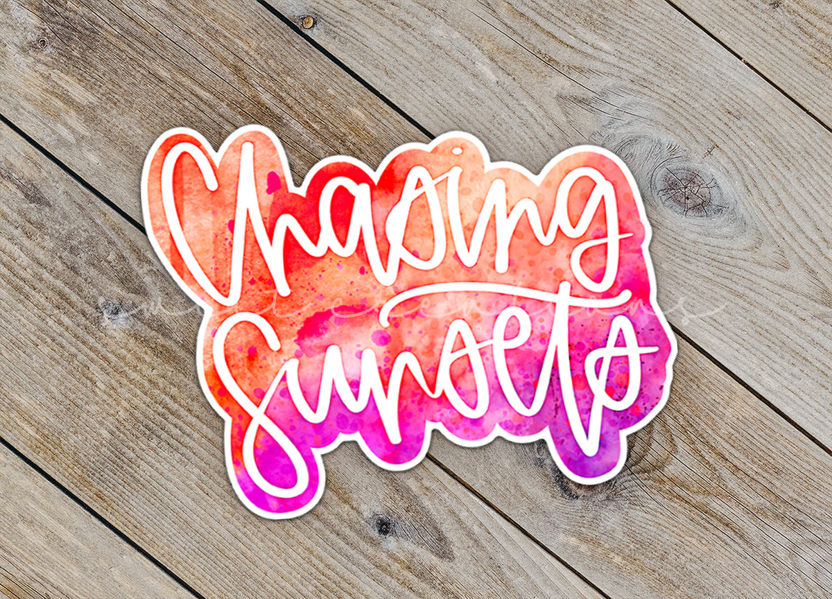 Close-up of the Chasing Sunsets sticker on rustic wood