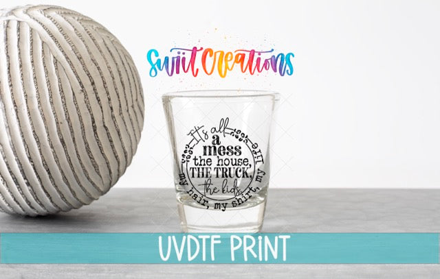 a ball of yarn next to a glass