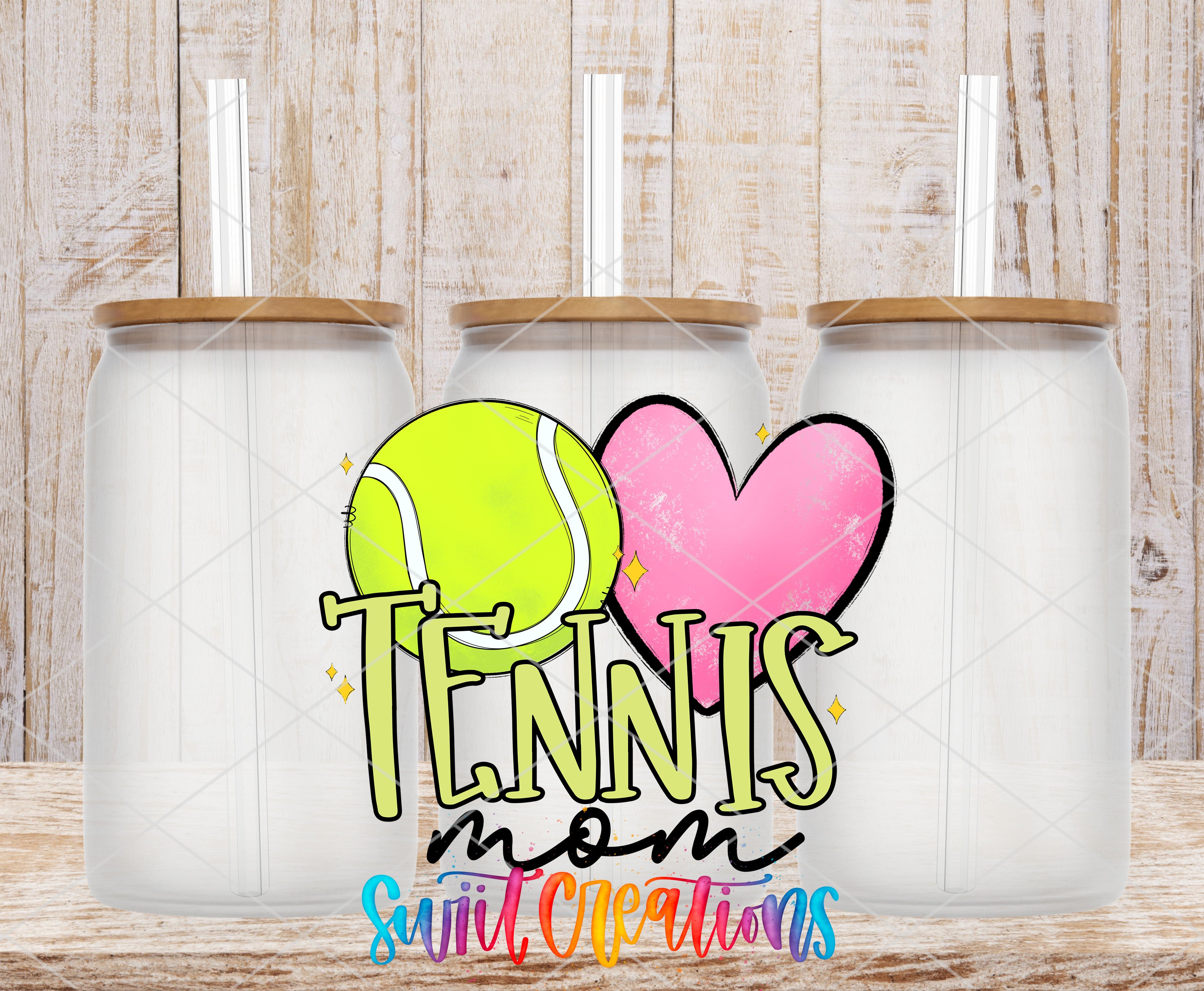 three glass jars with lids, each containing a straw, arranged in a row. The jars are set against a wooden background. The jars are labeled with the text "Tennis mom" and "suite cleanings" in a colorful, stylized font.