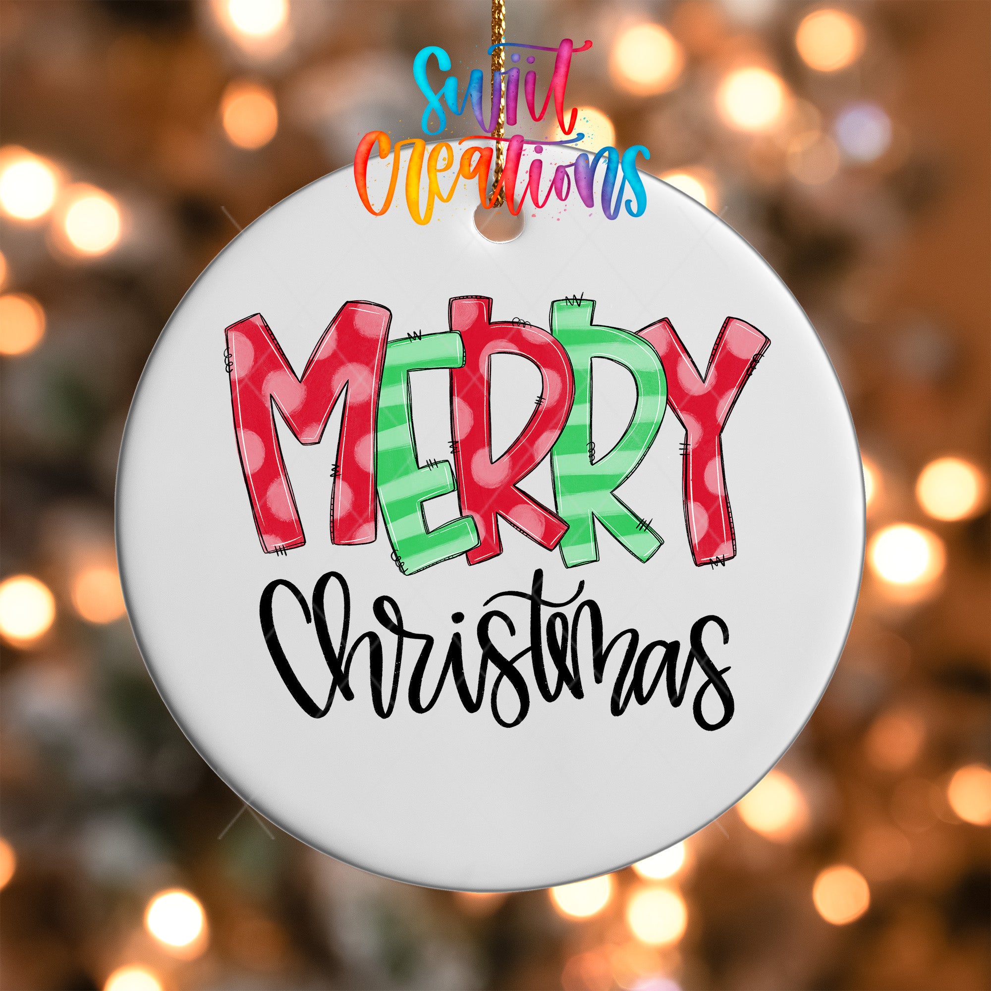 A white ceramic ornament with the text "MERRY CHRISTMAS" written in a colorful, hand-drawn style.