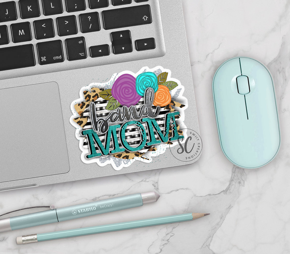 Leopard Floral Band Mom vinyl sticker on a silver laptop next to a mint mouse and pens