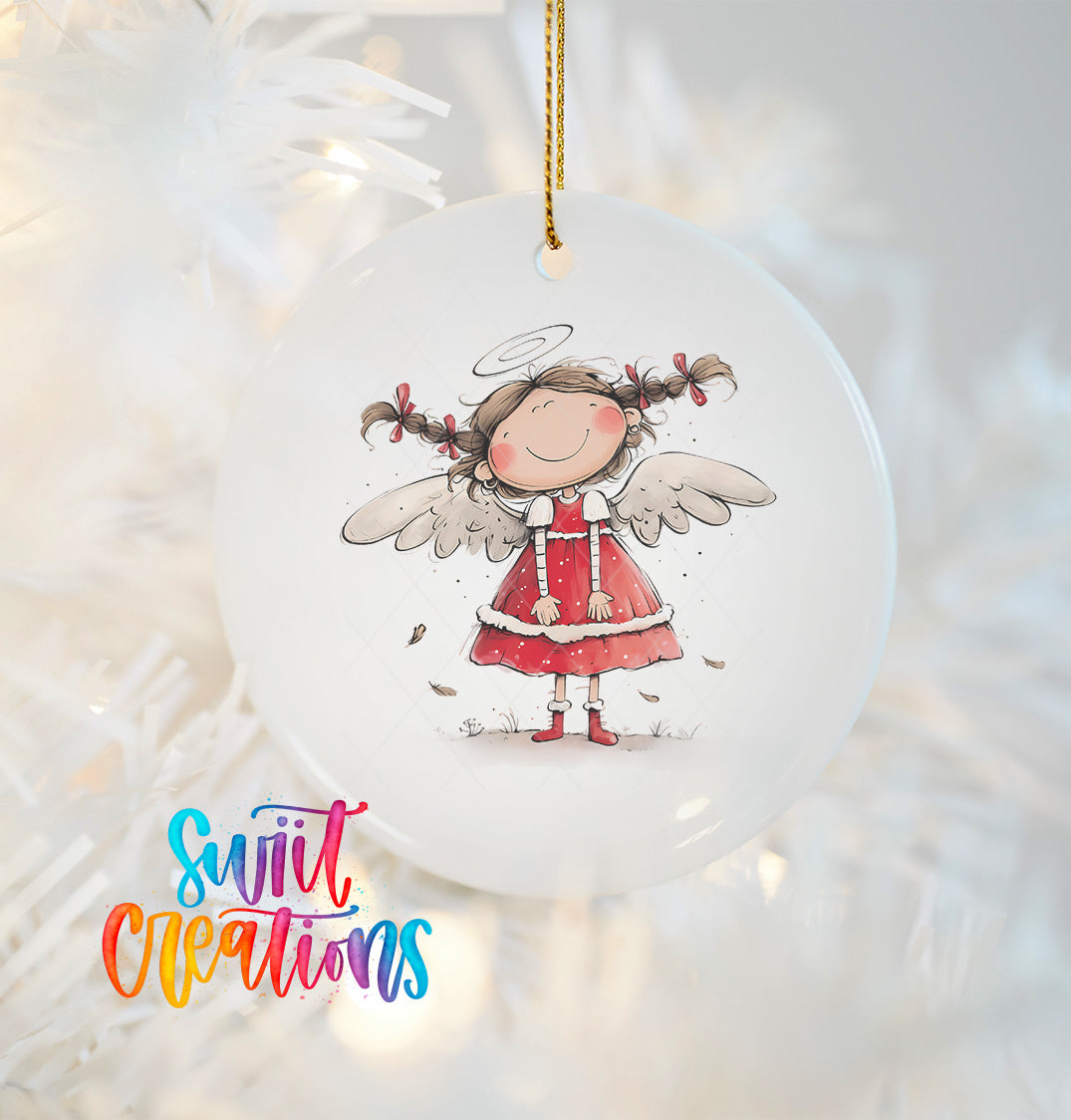 A white ornament featuring a smiling angel with wings, wearing a red dress and holding a halo, hanging on a Christmas tree.