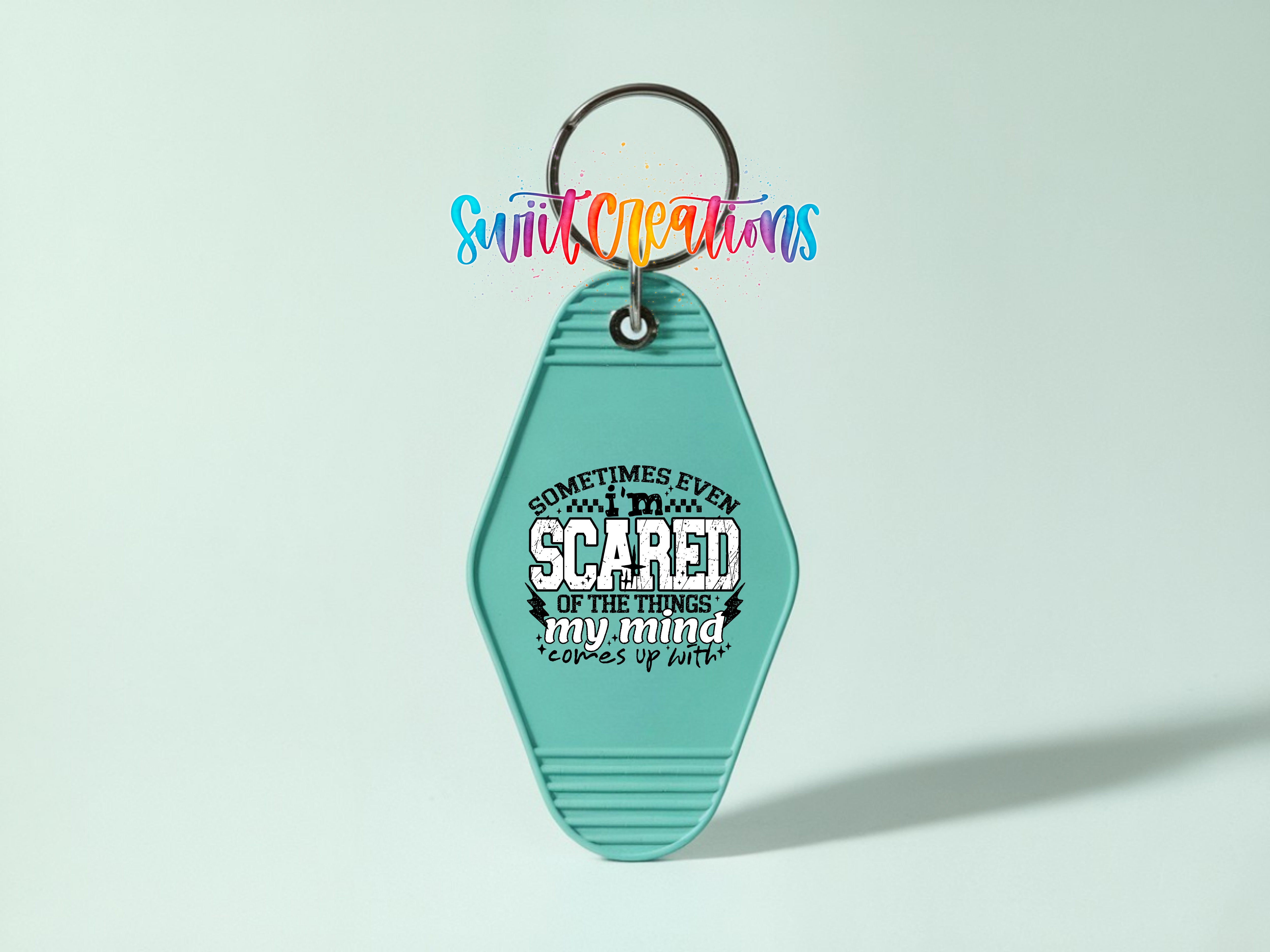 A turquoise keychain with a printed message on it.