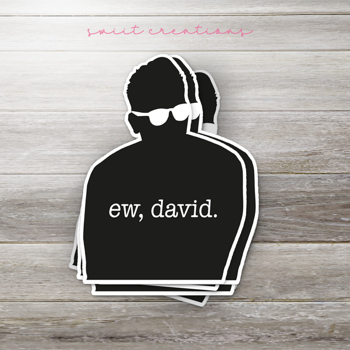 Stack of Ew David Silhouette glossy stickers on a gray wood table