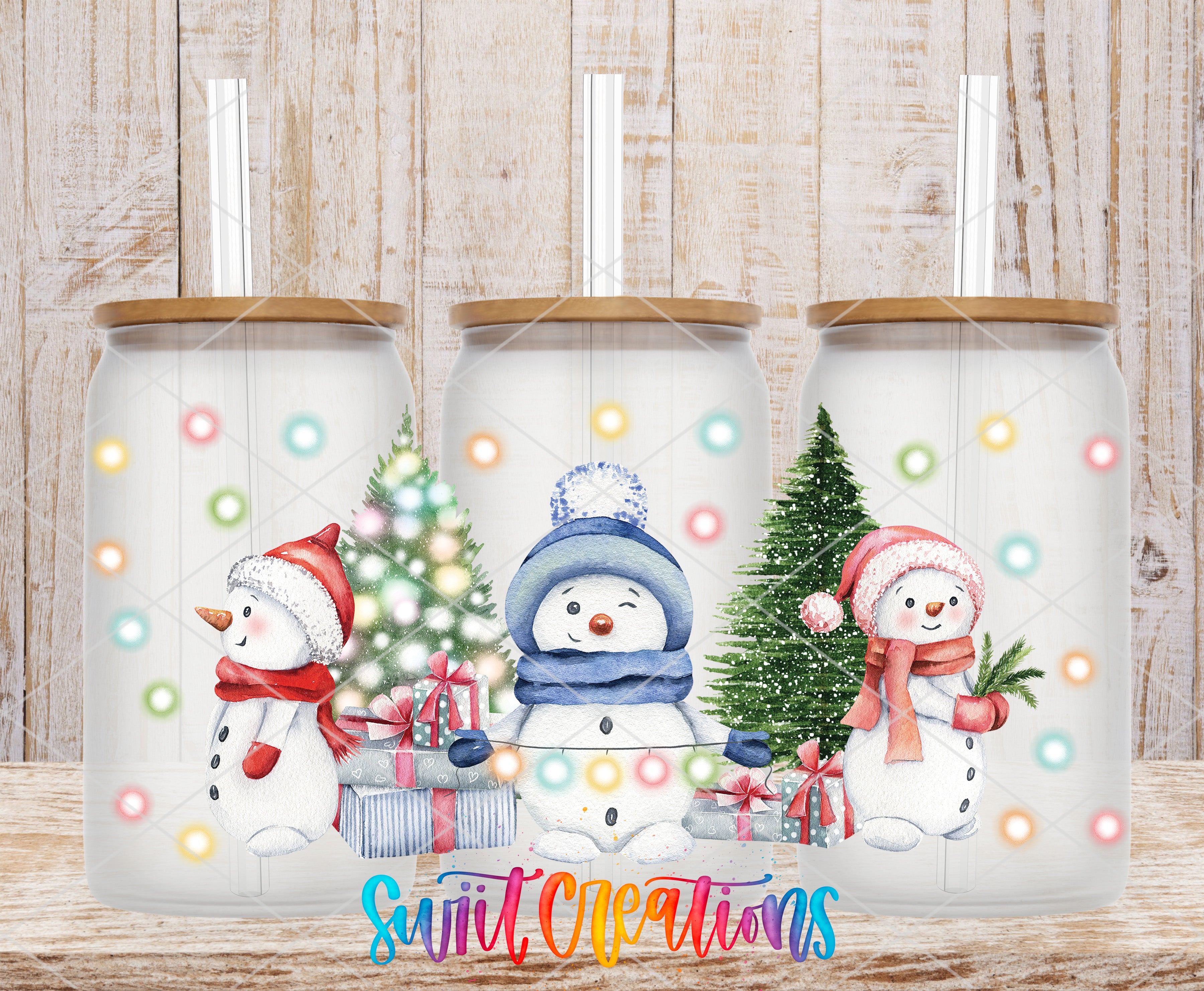 A collage of three glass jars with illustrations of snowmen and Christmas trees, each with a straw, against a wooden background.